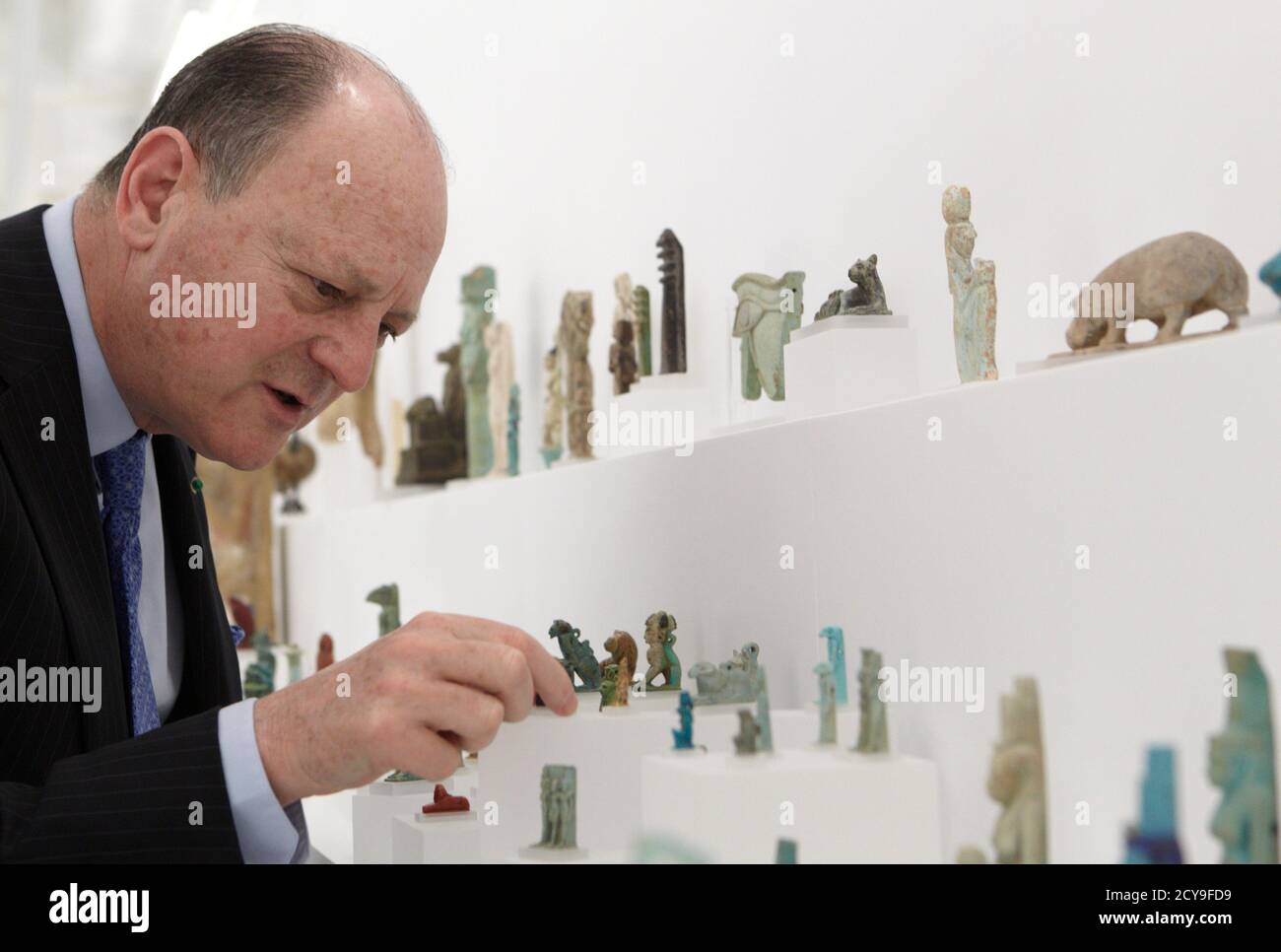 Art Collector Jean-Claude Gandur points to a series of ancient Egyptian  amulets and figurines from his collection of more than 850 Egyptians  antiquities during an interview with Reuters in Geneva April 21,