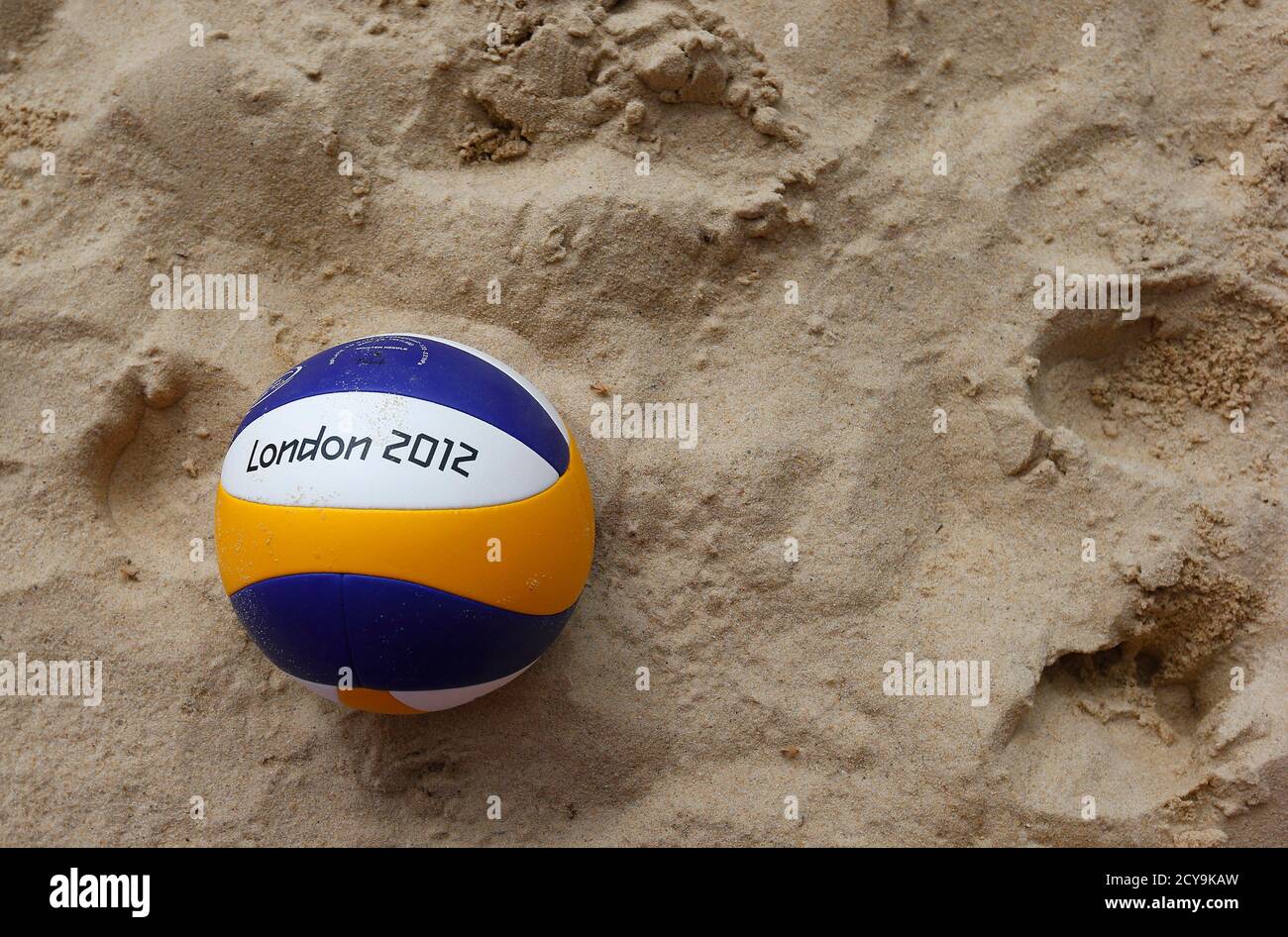 A London 2012 beach volleyball lies on the sand following a training session at the London 2012 Olympics beach volleyball venue in central London July 19, 2012. REUTERS/Suzanne Plunkett (BRITAIN - Tags: SPORT OLYMPICS SOCIETY VOLLEYBALL) Stock Photo