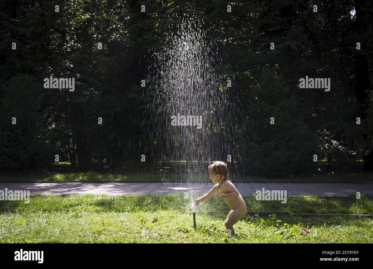 A child plays with a water sprinkler in a park during a a hot day in Almaty, Kazakhstan, July 16, 2015. The day temperature in Almaty reached 38 degrees Celsius (100 degrees Fahrenheit). REUTERS/Shamil Zhumatov Stock Photo