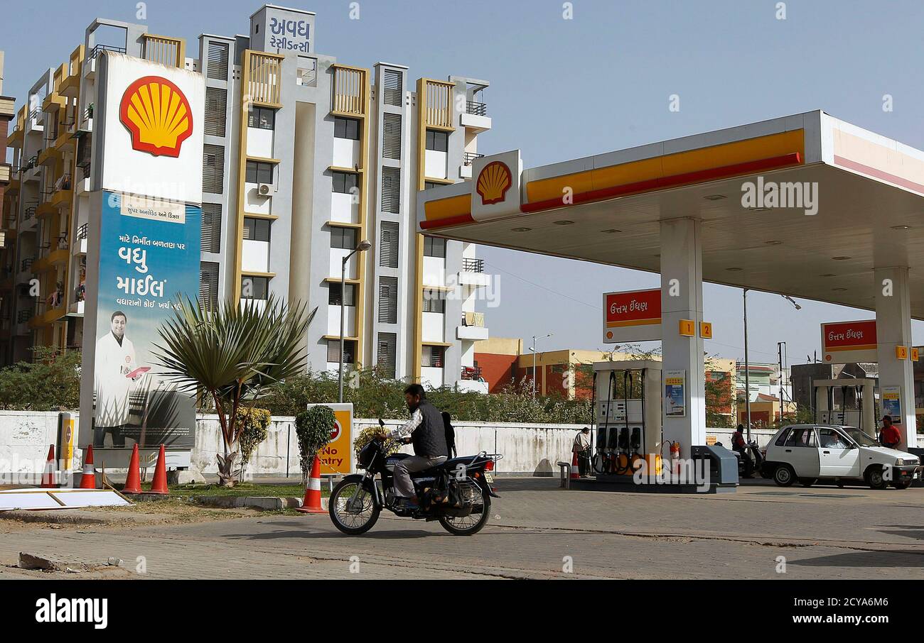 A man rides his motorcycle past a Shell fuel station on the outskirts of  the western Indian city of Ahmedabad February 6, 2013. Anglo-Dutch oil  major Royal Dutch Shell's Indian unit will