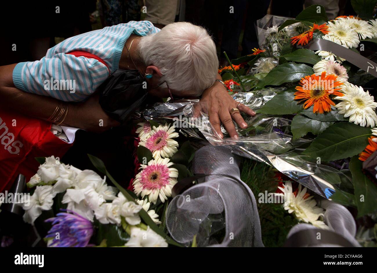 A mourner leans on flowers placed on the grave of fallen Israeli soldier Max Steinberg during his funeral at Mount Herzl military cemetery in Jerusalem July 23, 2014. Steinberg, a 23 year-old American from California's San Fernando Valley, was among 13 Israeli Defense Forces soldiers killed on Sunday during fighting in Gaza. REUTERS/Siegfried Modola (JERUSALEM - Tags: CONFLICT POLITICS CIVIL UNREST MILITARY) Stock Photo