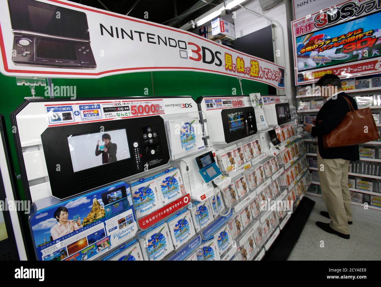 A man tries out Nintendo's 3DS game player at an electronic store in Tokyo  April 25, 2011. Japan's Nintendo Co posted its second straight fall in  annual profit on Monday, as sales