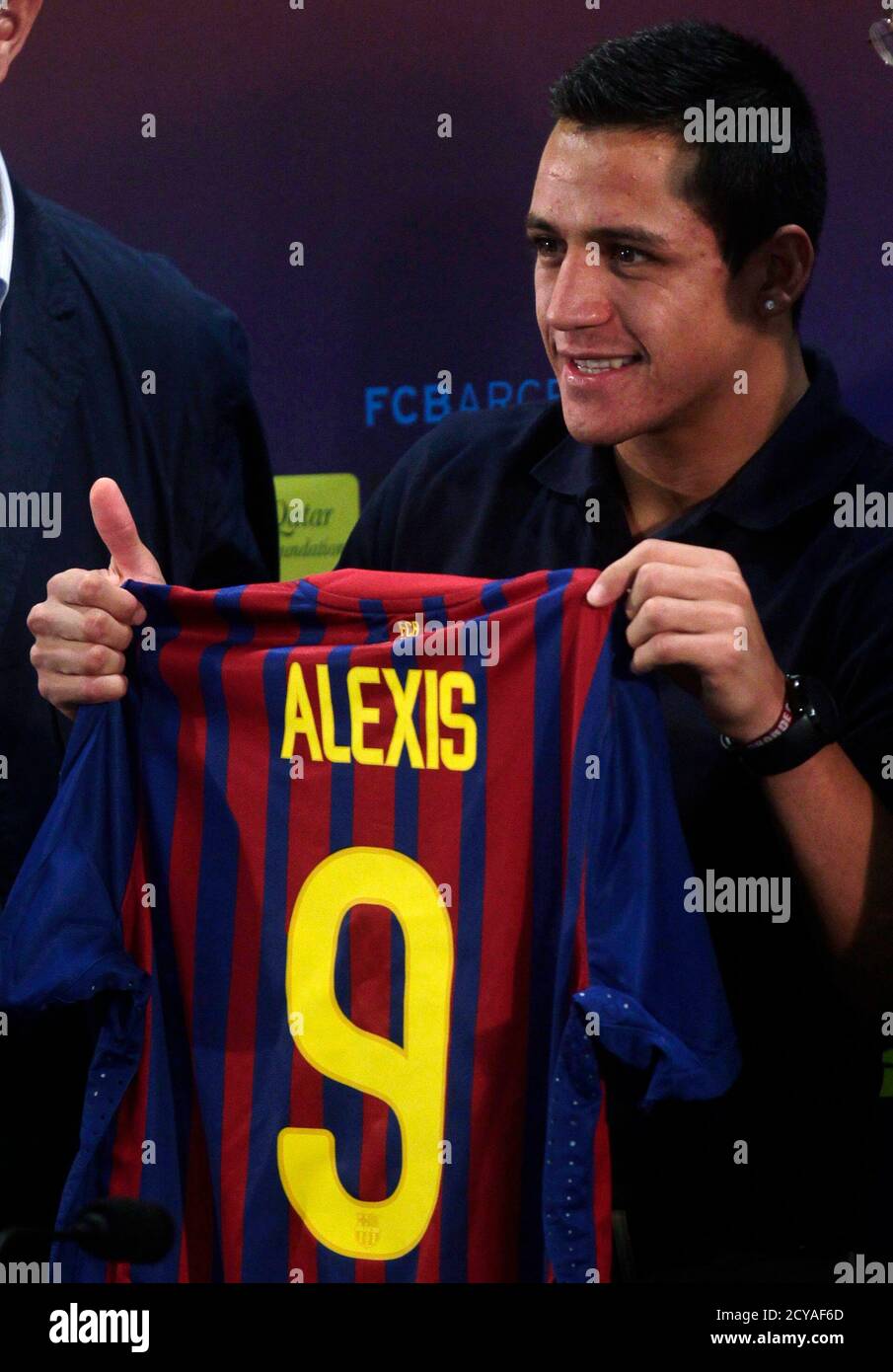 Barcelona's new soccer player Alexis Sanchez from Chile poses with his new  club jersey in Barcelona July 25, 2011, after signing a five-year contract  with the Spanish and European champions. REUTERS/Albert Gea (