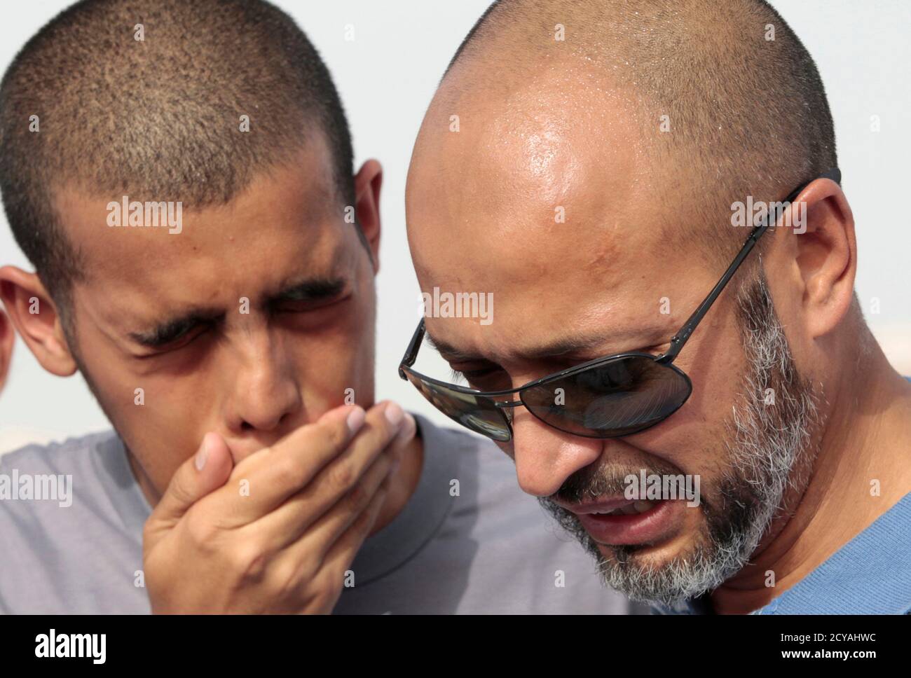 The father (R) of a South African teenager killed during a Doha mall fire  cries next to his other son, during a funeral procession in Doha May 29,  2012. Qatar's interior ministry