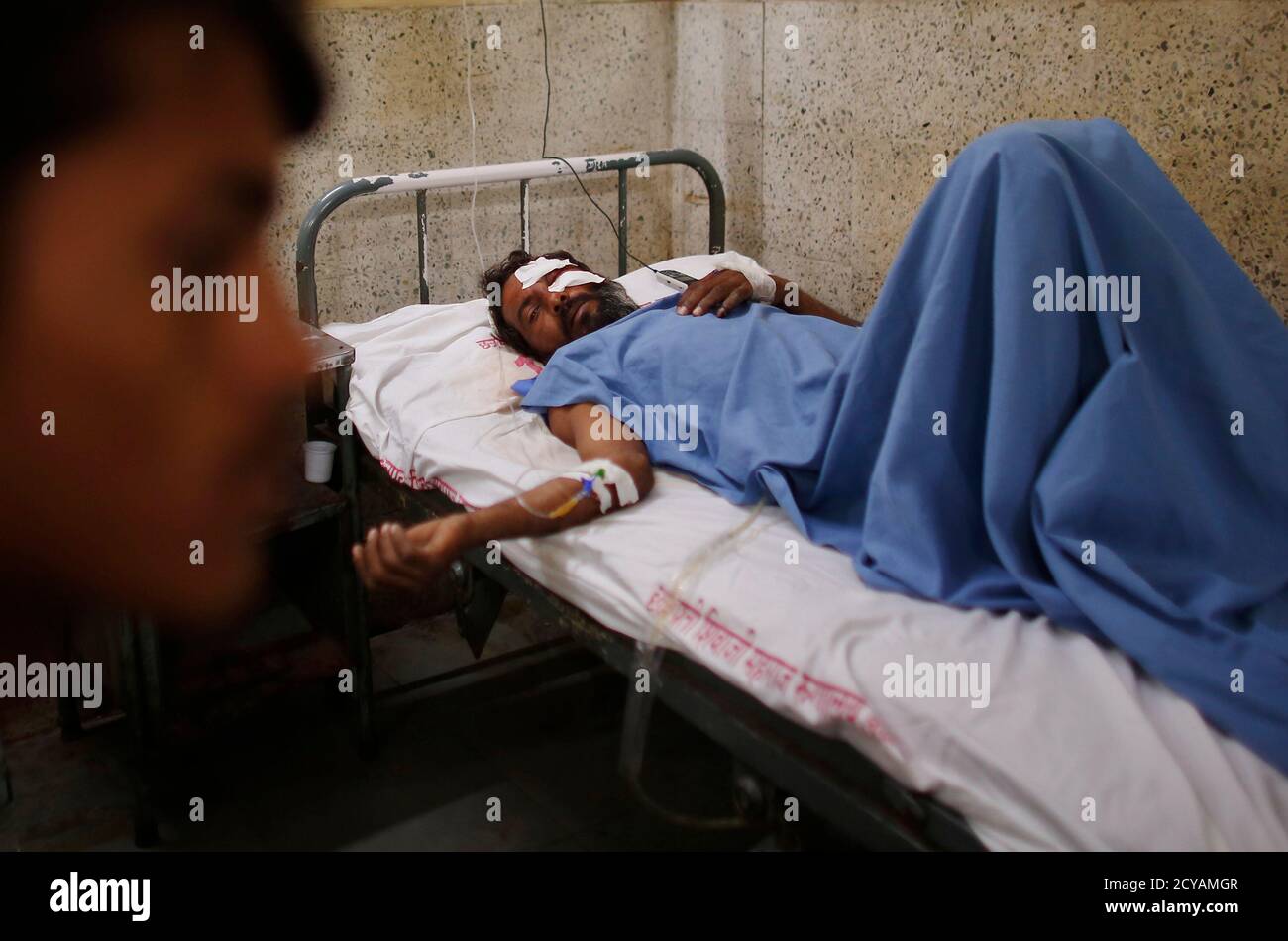 A man who was injured during the collapse of a residential building, lies  on a hospital bed in Thane district, on the outskirts of Mumbai April 5,  2013. At least 39 people