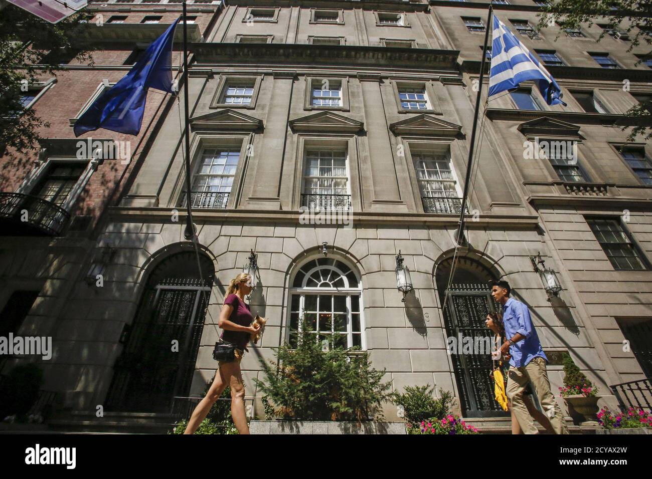 The flags of the European Union and Greece flutter as people walk in front of the Greece consulate in New York June 30, 2015. REUTERS/Eduardo Munoz Stock Photo