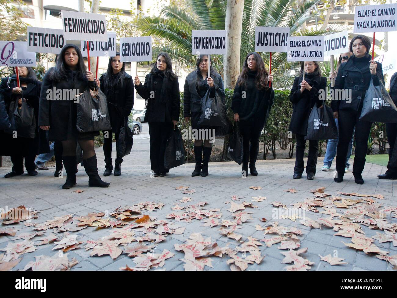 Women from Guatemala carry banners as they protest during the International Day for the Elimination of Violence against Women in front of the Guatemalan embassy in Madrid November 25, 2011. The protest is held to denounce the crimes committed against women during the internal armed conflict in Guatemala. Banners read 'Feticide', 'Femicide' and 'Justice'. REUTERS/Andrea Comas (SPAIN - Tags: CIVIL UNREST POLITICS) Stock Photo