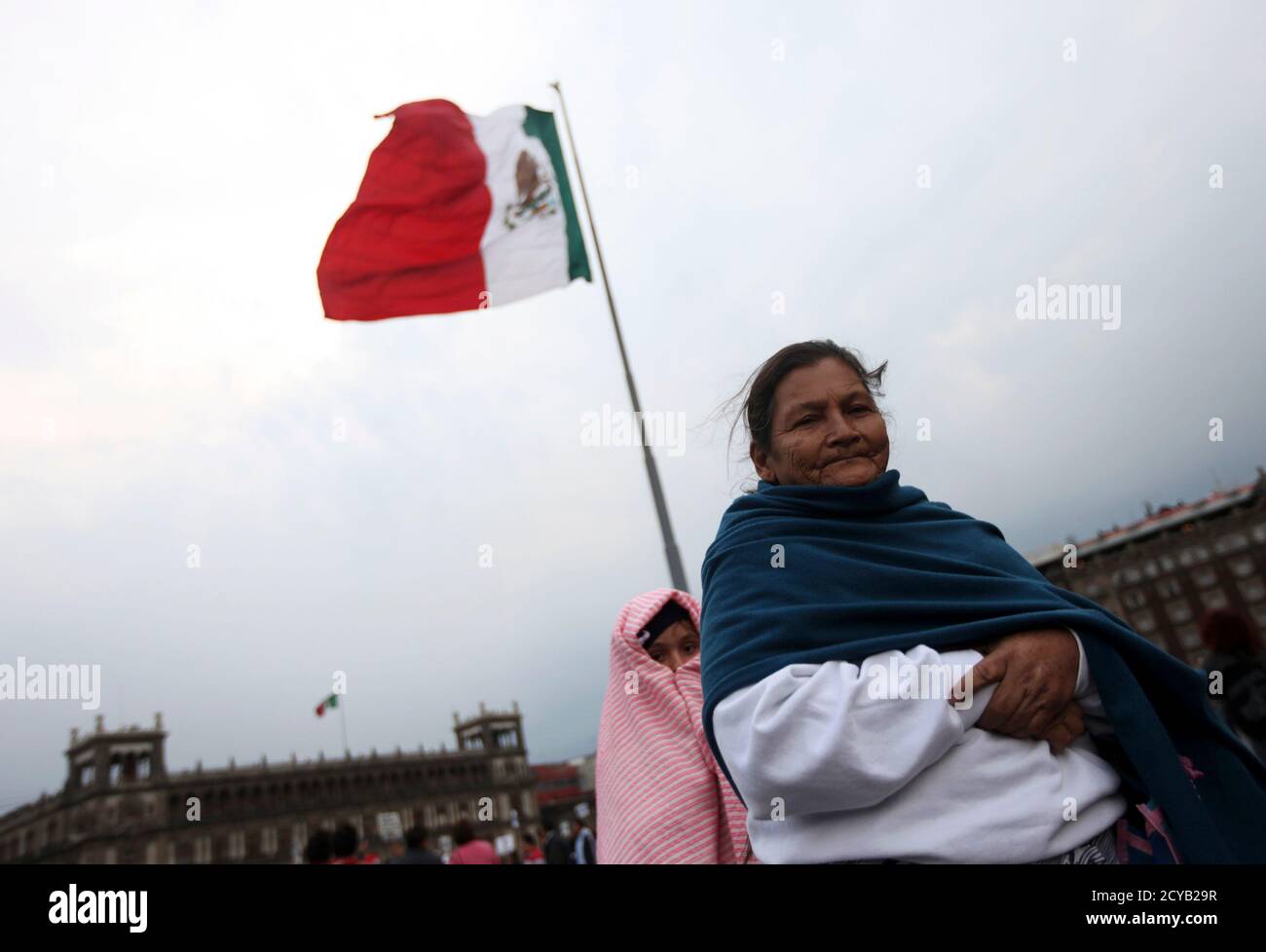 A woman and a girl stand near a Mexican flag during a protest march in Mexico City January 31, 2012. Thousands of protesters and union workers took to the streets in a march called 'Movement for Food and Energy Sovereignty, Worker's Rights and Democratic Freedom', to protest about economic issues affecting them such as unemployment and the ongoing drought causing severe shortage of food and water. REUTERS/Edgard Garrido (MEXICO - Tags: POLITICS CIVIL UNREST BUSINESS) Stock Photo