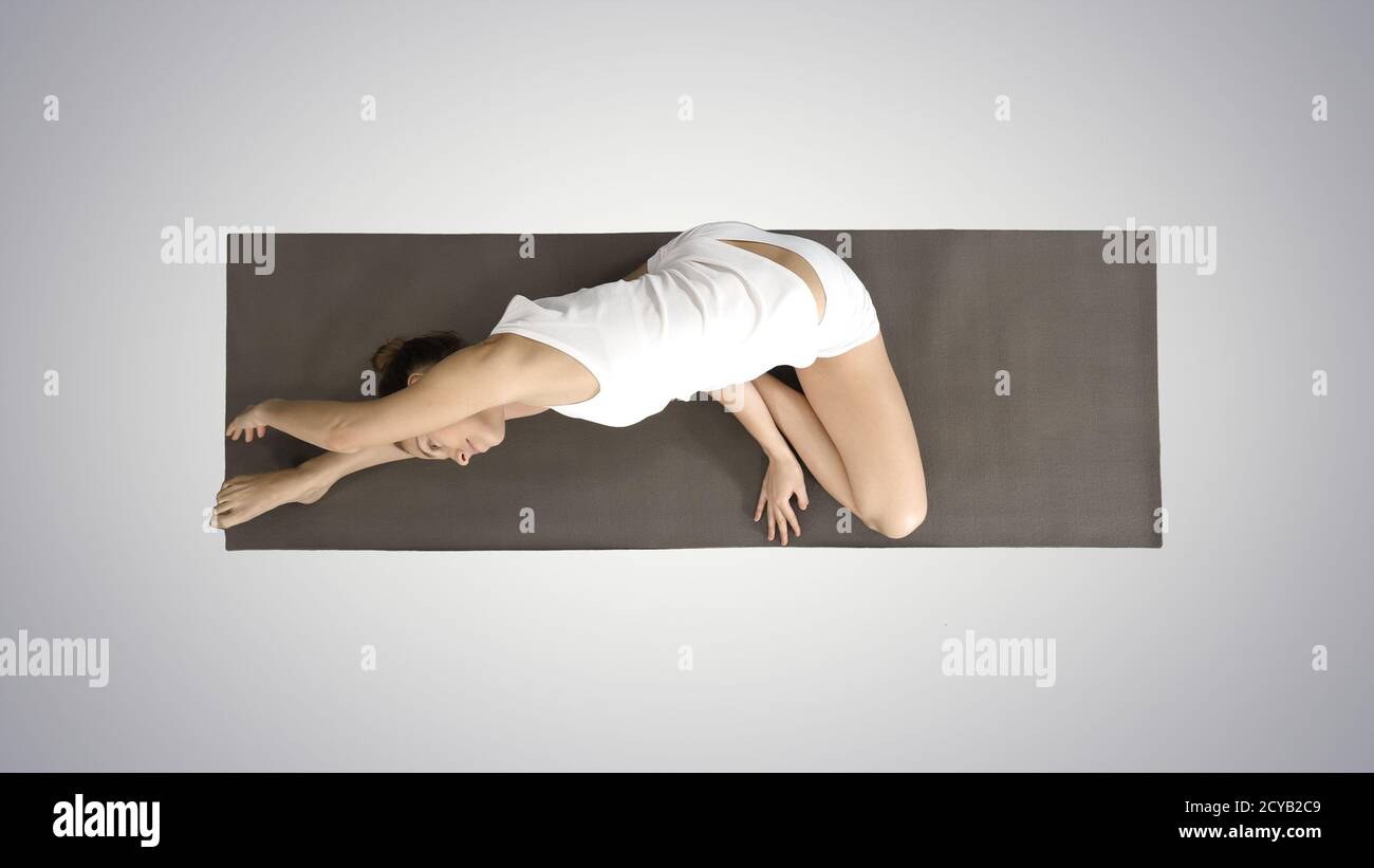 Beautiful young woman wearing white clothing doing yoga exercise Stock Photo