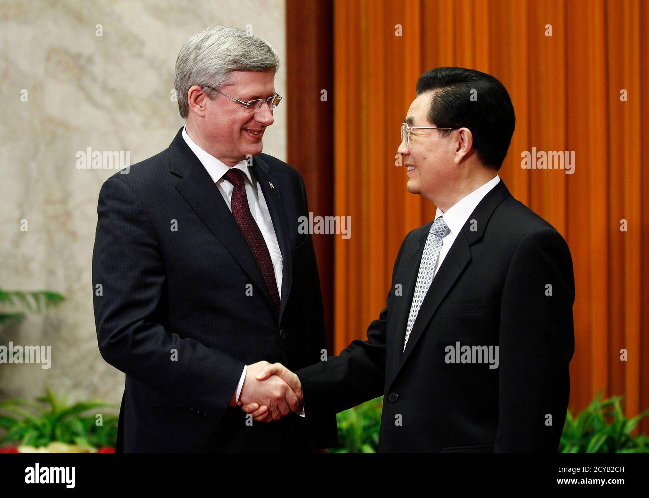 Canada's Prime Minister Stephen Harper (L) shakes hands with China's President Hu Jintao at the Great Hall of the People in Beijing February 9, 2012. China and Canada on Wednesday signed a series of deals to boost modest levels of bilateral trade and finished negotiations on a foreign investment protection pact after 18 years of talks.      REUTERS/Chris Wattie       (CHINA - Tags: POLITICS) Stock Photo