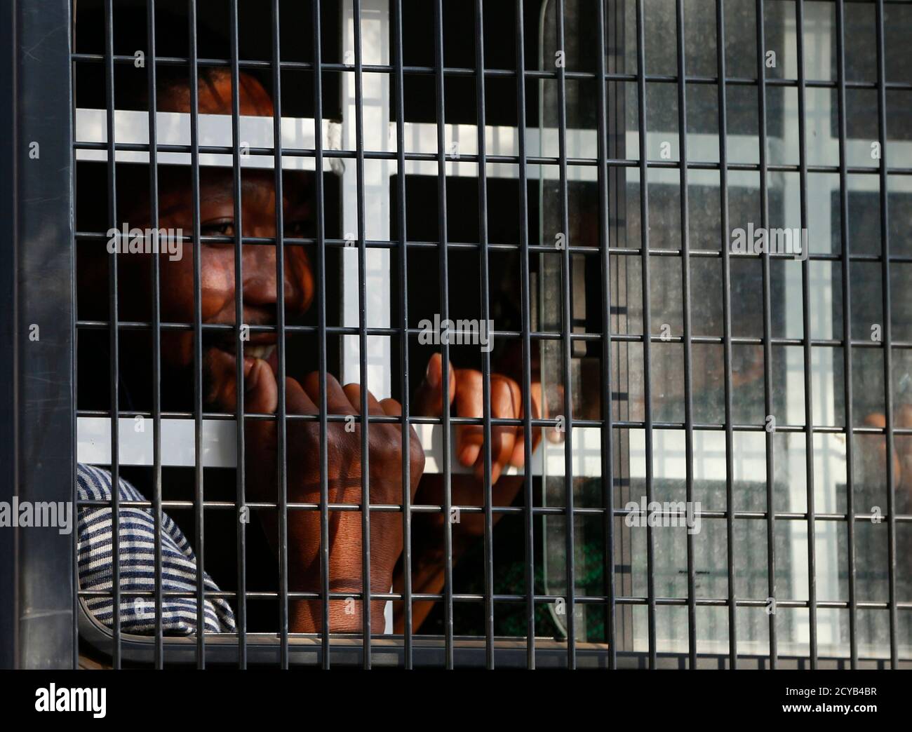 A detained miner peers out of a police van as it arrives at court in Ga Rankuwa, near Pretoria September 3, 2012. South Africa released on Monday the first of 270 miners detained more than two weeks ago after police shot dead 34 of their colleagues in a bid to break up a wildcat strike at Lonmin's Marikana platinum mine.The men were charged last week under an obscure apartheid-era security law with murdering their fellow miners, although state prosecutors withdrew the charges at the weekend following a public outcry. REUTERS/Mike Hutchings (SOUTH AFRICA - Tags: POLITICS BUSINESS COMMODITIES EM Stock Photo