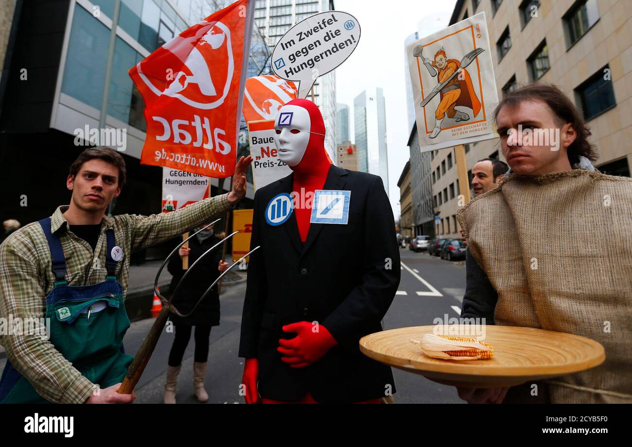 A demonstrator with a placard reading 'in doubt against the hungry' (C) stands in front of the headquarters of Germany's largest business bank, Deutsche Bank, as he demonstrates against speculations with food prices before the bank's annual news conference in Frankfurt, January 31, 2013. Deutsche Bank posted a $3.5 billion quarterly loss as it took legal and restructuring charges aimed at drawing a line under past scandals and boosting its capital position in a tougher regulatory and trading environment.  REUTERS/Kai Pfaffenbach (GERMANY - Tags: BUSINESS CIVIL UNREST) Stock Photo