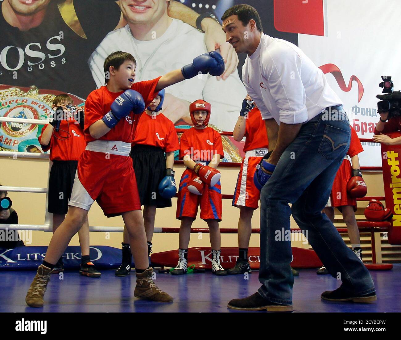IBF, WBO and IBO heavyweight champion boxer Vladimir Klitschko (R) of  Ukraine helps out with training during a session with the best young  Ukranian boxers in Kiev March 2, 2011. REUTERS/Gleb Garanich (