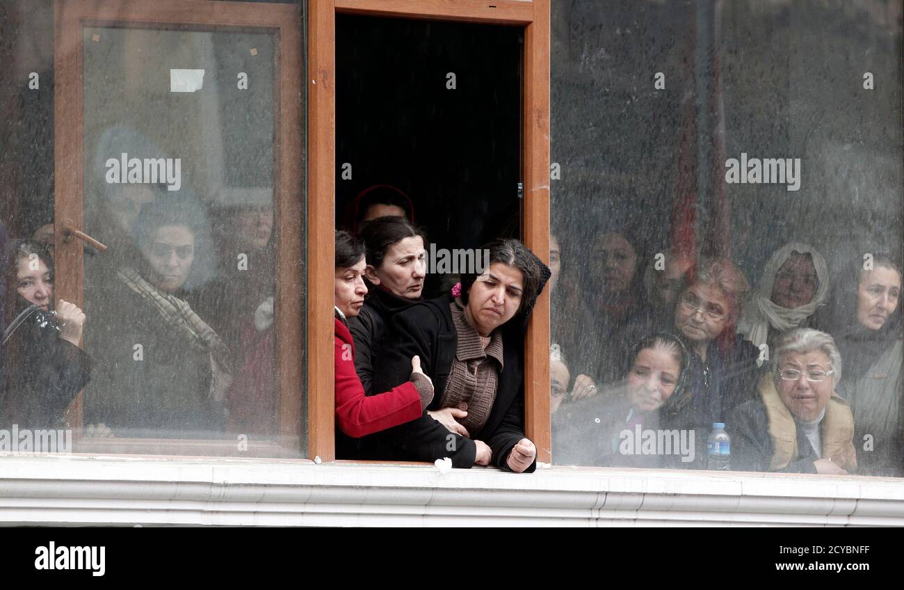 Mourning women, including Berkin Elvan's mother Gulsum Elvan (C-R), look out from Okmeydani cemevi in Istanbul March 11, 2014. Berkin Elvan, a 15-year-old Turkish boy who suffered a head injury during anti-government protests in Istanbul last June died on Tuesday after spending months in a coma, triggering renewed clashes between police and his family's supporters. Berkin Elvan, then aged 14, got caught up in street battles between police and protesters on June 16 after going out to buy bread for his family. He was struck in the head with a suspected police tear-gas canister and went into a co Stock Photo