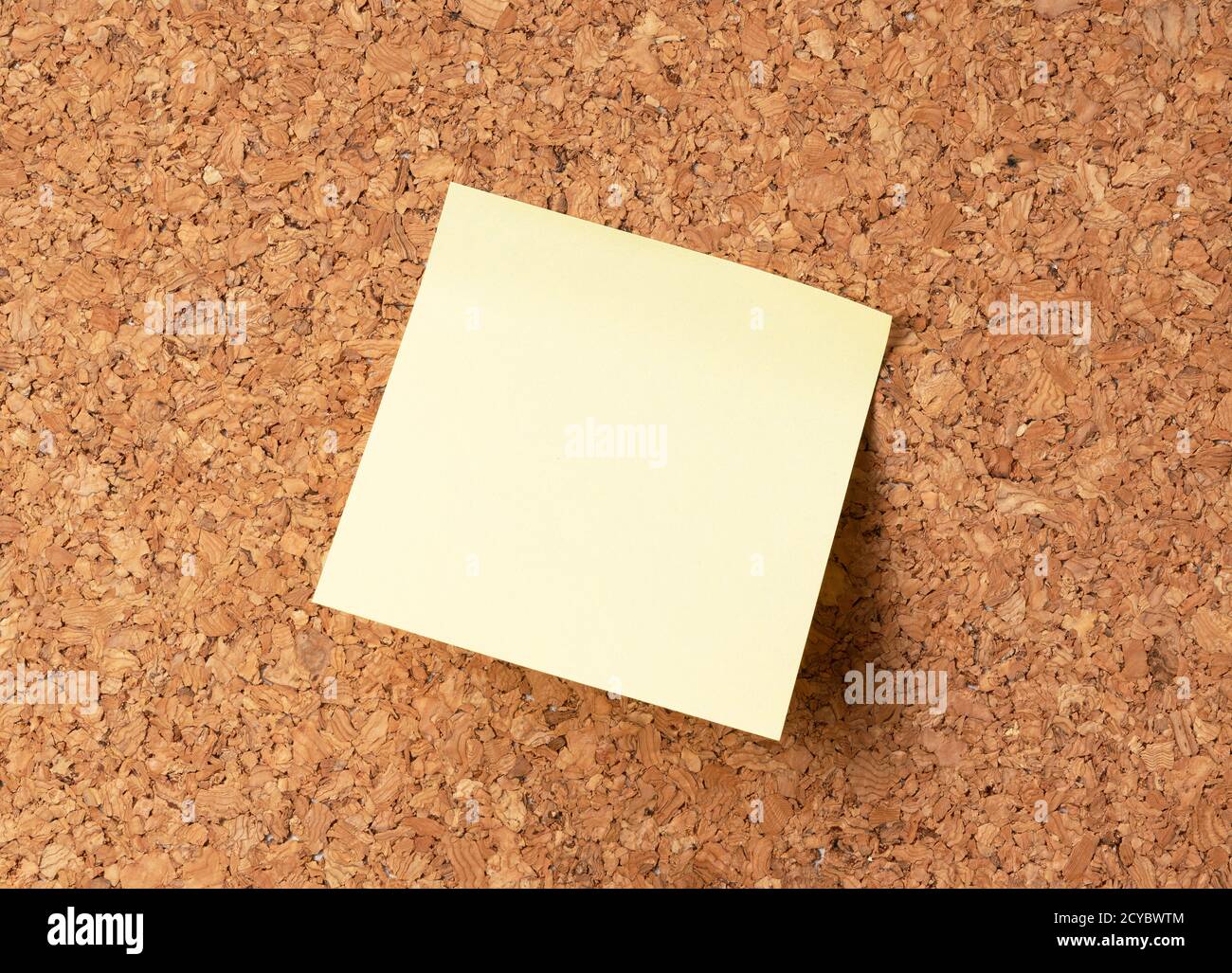 Yellow sticky note on corkboard Stock Photo