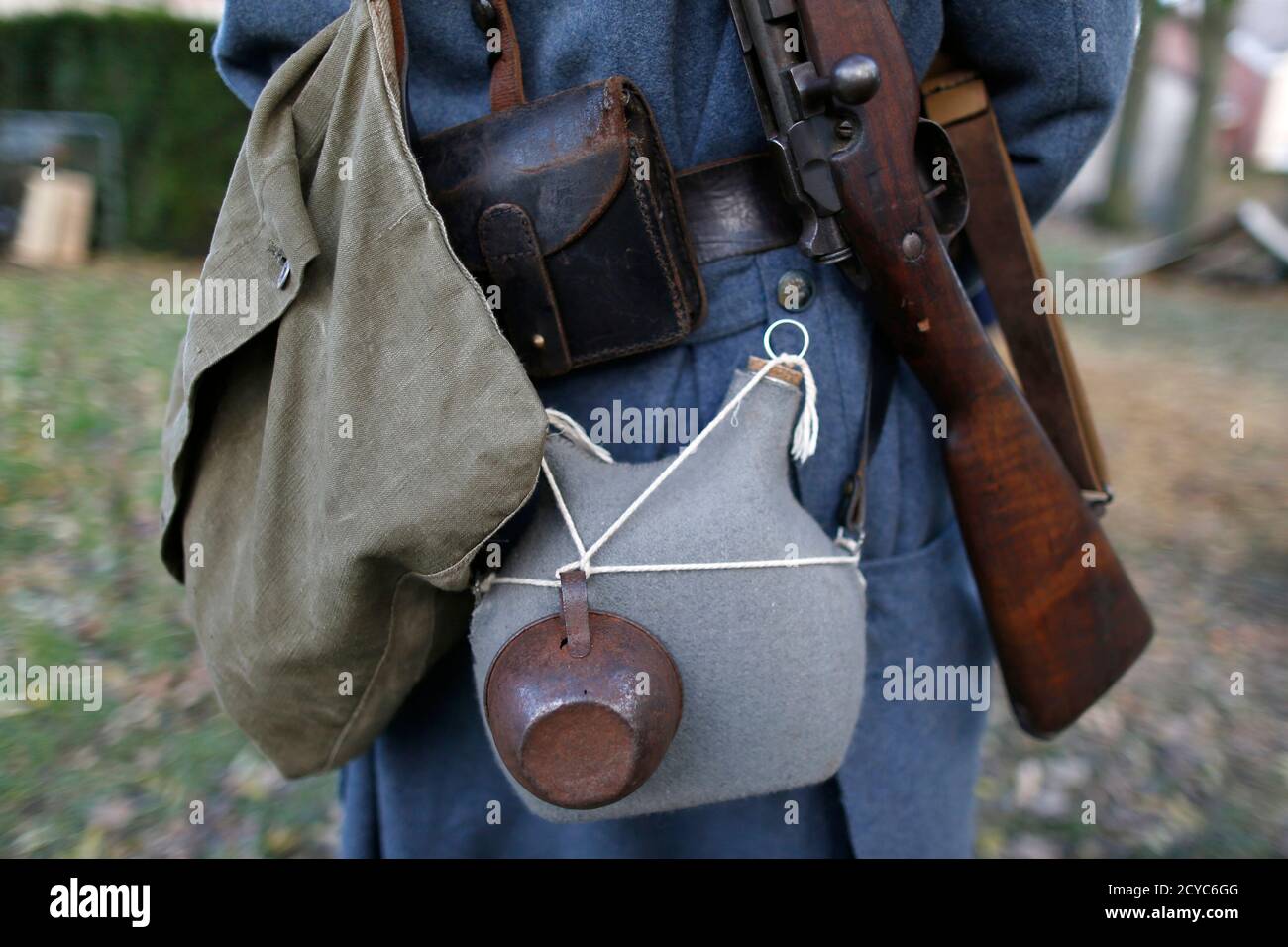 Flask, mug and gun are carried by a World War One Historical Association '14-18 en Somme' member at a bivouac camp in Fouilloy Northern France, November 10, 2013. The historical association '14-18 en Somme' was created in August 2009 by French history teacher Sylvain Pinard with the aim of keeping alive the memory of the soldiers of World War One, and promoting understanding of the battles of the Great War. Armed with their motto 'Never forget, always remember', the 30 members live, eat and sleep in the same conditions as the soldiers of 1914-18. Throughout the year, they take part in official Stock Photo