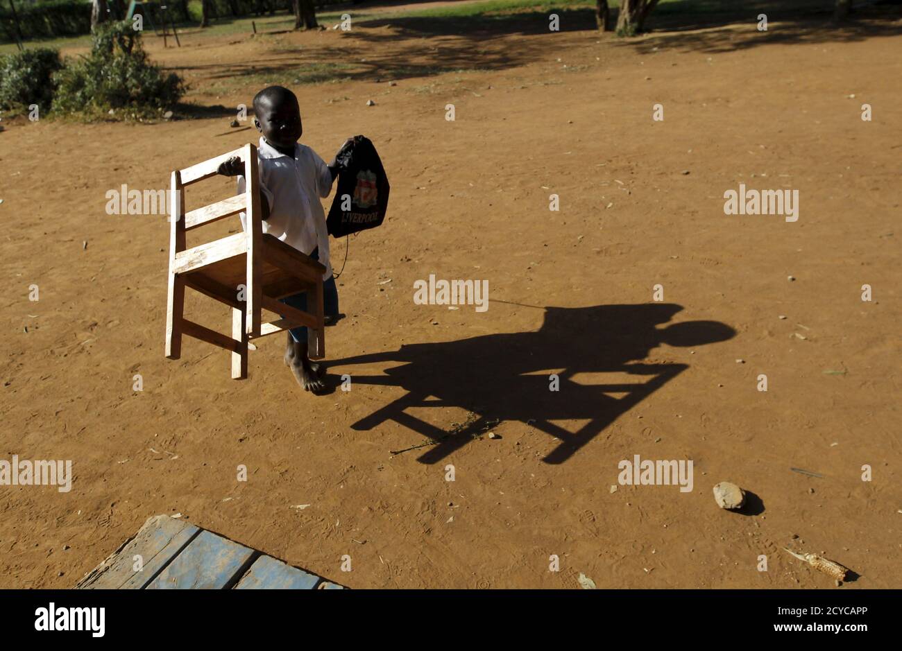 A boy carries a chair at the Senator Obama primary school in the U.S. President Barack Obama's ancestral village of Nyang'oma Kogelo, west of Kenya's capital Nairobi, July 16, 2015. Obama visits Kenya and Ethiopia in July, his third major trip to Sub-Saharan Africa after travelling to Ghana in 2009 and to Tanzania, Senegal and South Africa in 2011. He has also visited Egypt, in North Africa, and South Africa for Nelson Mandela's funeral. Obama will be welcomed by a continent that had expected closer attention from a man they claim as their son, a sentiment felt acutely in the Kenyan village wh Stock Photo
