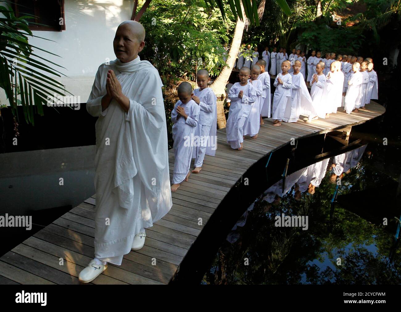 A Buddhist nun walks in line with novice Thai nuns at the Sathira  Dammasathan Buddhist meditation centre in Bangkok April 20, 2012. A small  but growing group of Thai girls are choosing