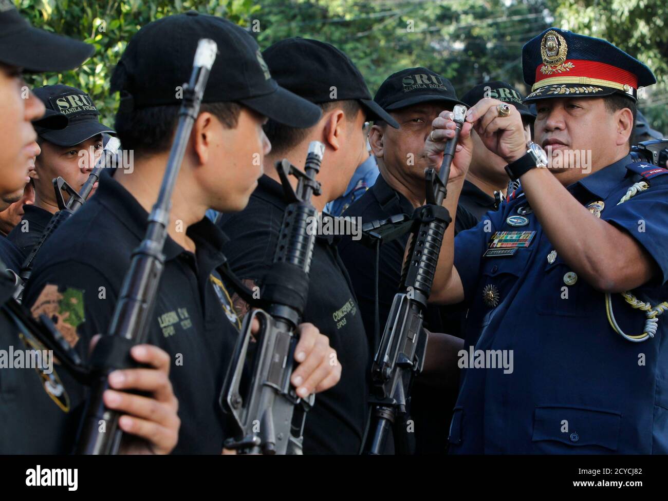 A Philippine National Police (PNP) officer removes tape as he unseals the muzzle of a service firearms of a member of the Special Weapons and Tactics (SWAT) team during the ceremonial unsealing of firearms at a police station in Manila January 2, 2013. The Department of Health (DOH) on Tuesday reported that 413 people were injured during New Year day celebrations in the Philippines - 405 were firework-related injuries, one of which was a case of firecracker ingestion. The remaining eight were wounded by stray bullets, with one victim dead. Police are investigating the cases of victims of the s Stock Photo