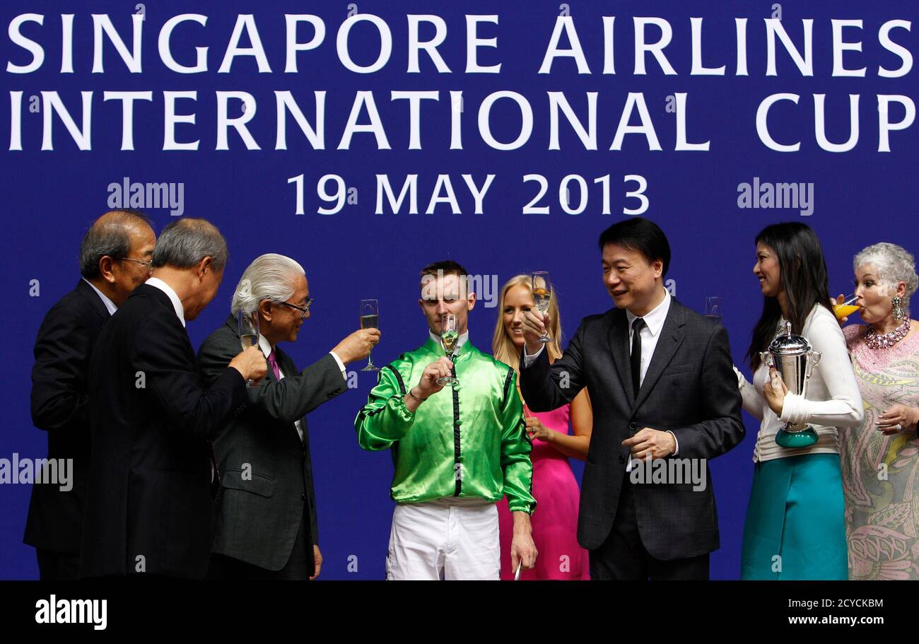 Jockey Zac Purton (C, in green), horse owners Steven Lo Kit Sing (3rd R) and his wife, are congratulated by Singapore's President Tony Tan (3rd L) after Military Attack of Hong Kong won the Singapore Airlines (SIA) International Cup horse at the Singapore Turf Club May 19, 2013. REUTERS/Edgar Su (SINGAPORE - Tags: SPORT HORSE RACING POLITICS) Stock Photo