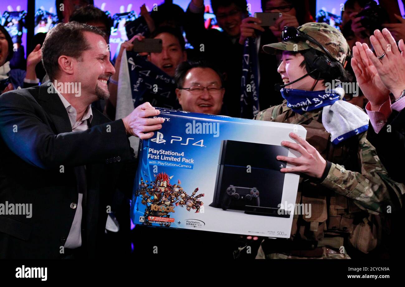 Sony Computer Entertainment Inc President And Group Ceo Andrew House L Hands A Playstation 4 Gaming Console To Ryo Watanabe 21 The First In Japan To Own The Gaming Console During Its