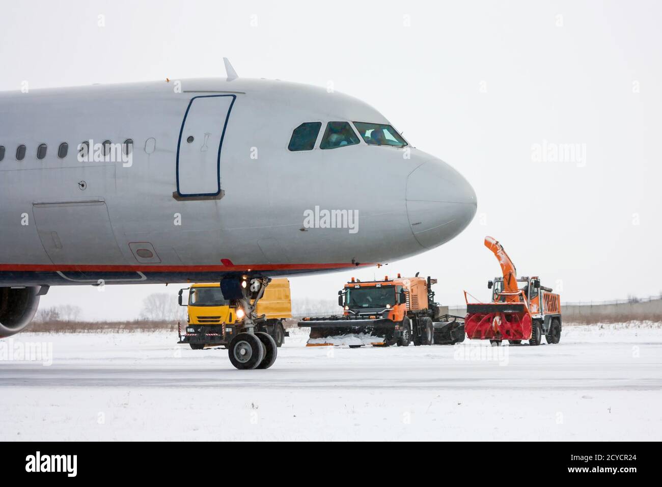 Airliner and snow removal equipment in a cold winter airport Stock