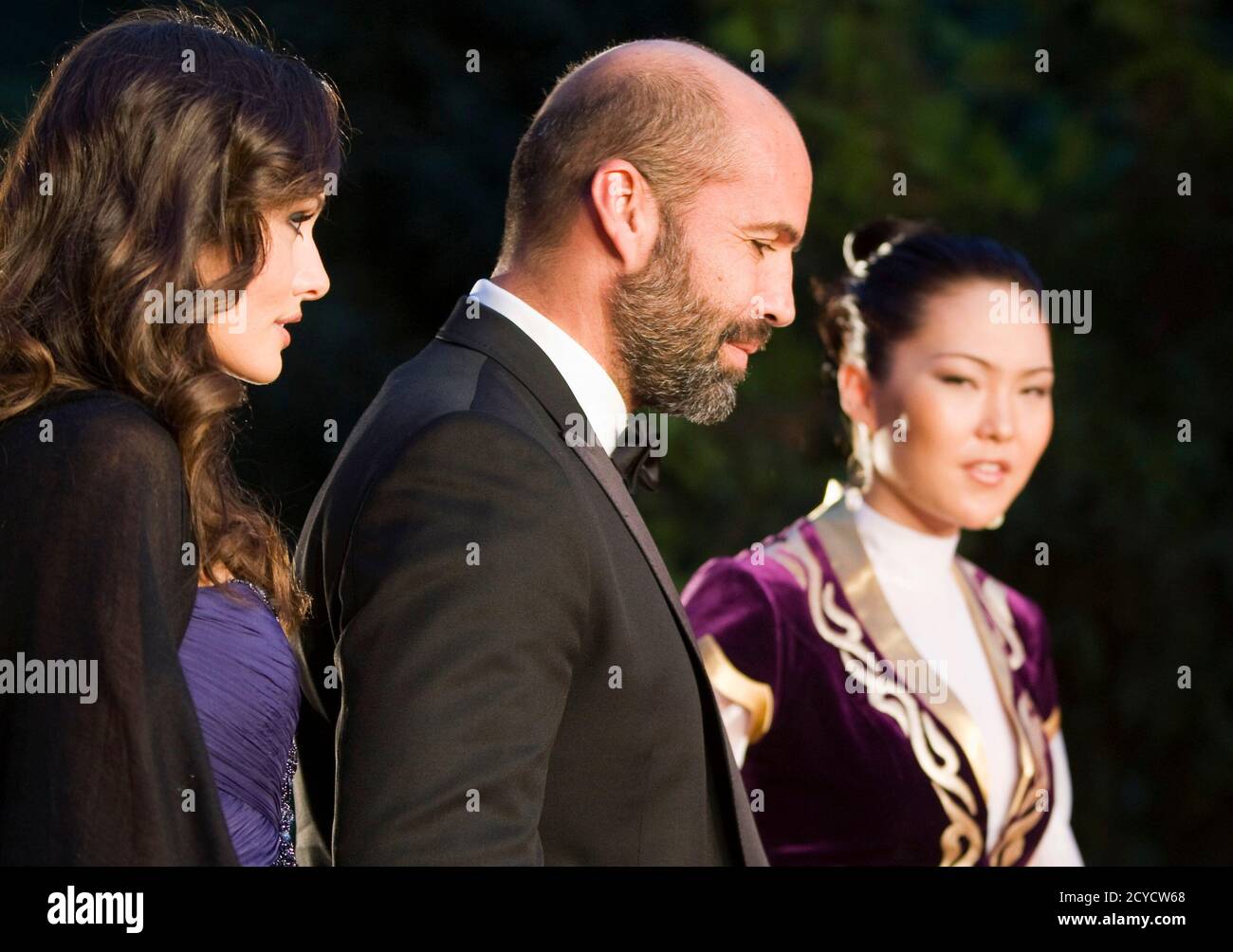 Actor Billy Zane (C), accompanied by an unidentified guest, walks on the  red carpet next to a Kazakh girl in national costume during the opening  ceremony of the Eurasia Film Festival in