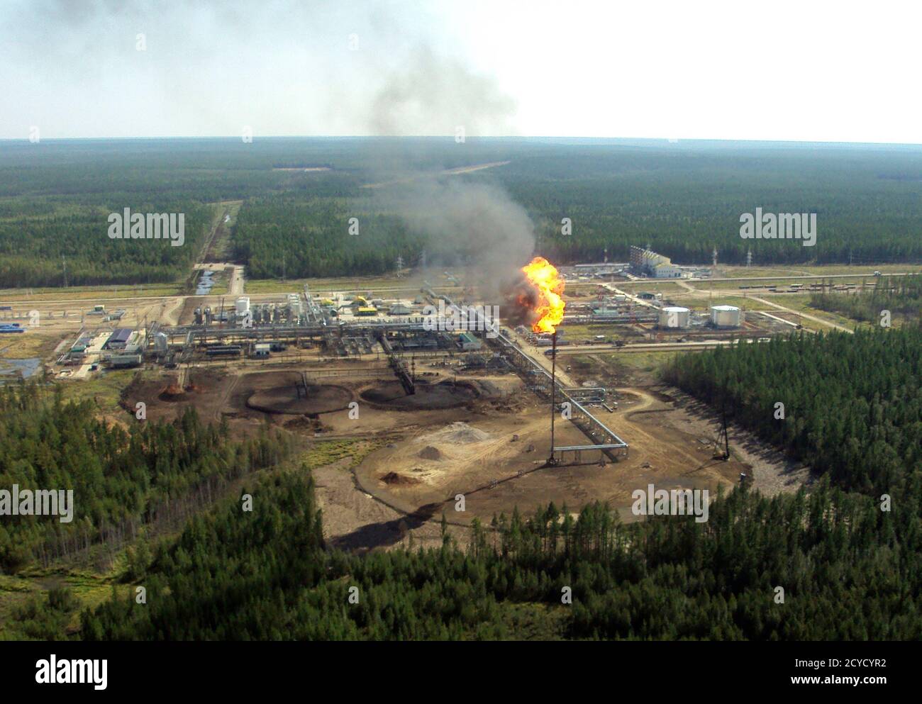 A huge flame burns off gas at an oil drilling station on an oil field in Verkhnechonsk, some 1100 km (683 miles) from Irkutsk in Eastern Siberia August 19, 2011. A consequence of the field's location is the fate of the associated gas extracted as a by-product of oil production from the gas-rich field. For lack of a nearby market, hundreds of millions of dollars worth of gas is burnt off, or flared. Picture taken August 19, 2011. To match Feature TNKBP-SIBERIA/  REUTERS/Melissa Atkin (RUSSIA - Tags: BUSINESS ENERGY) Stock Photo