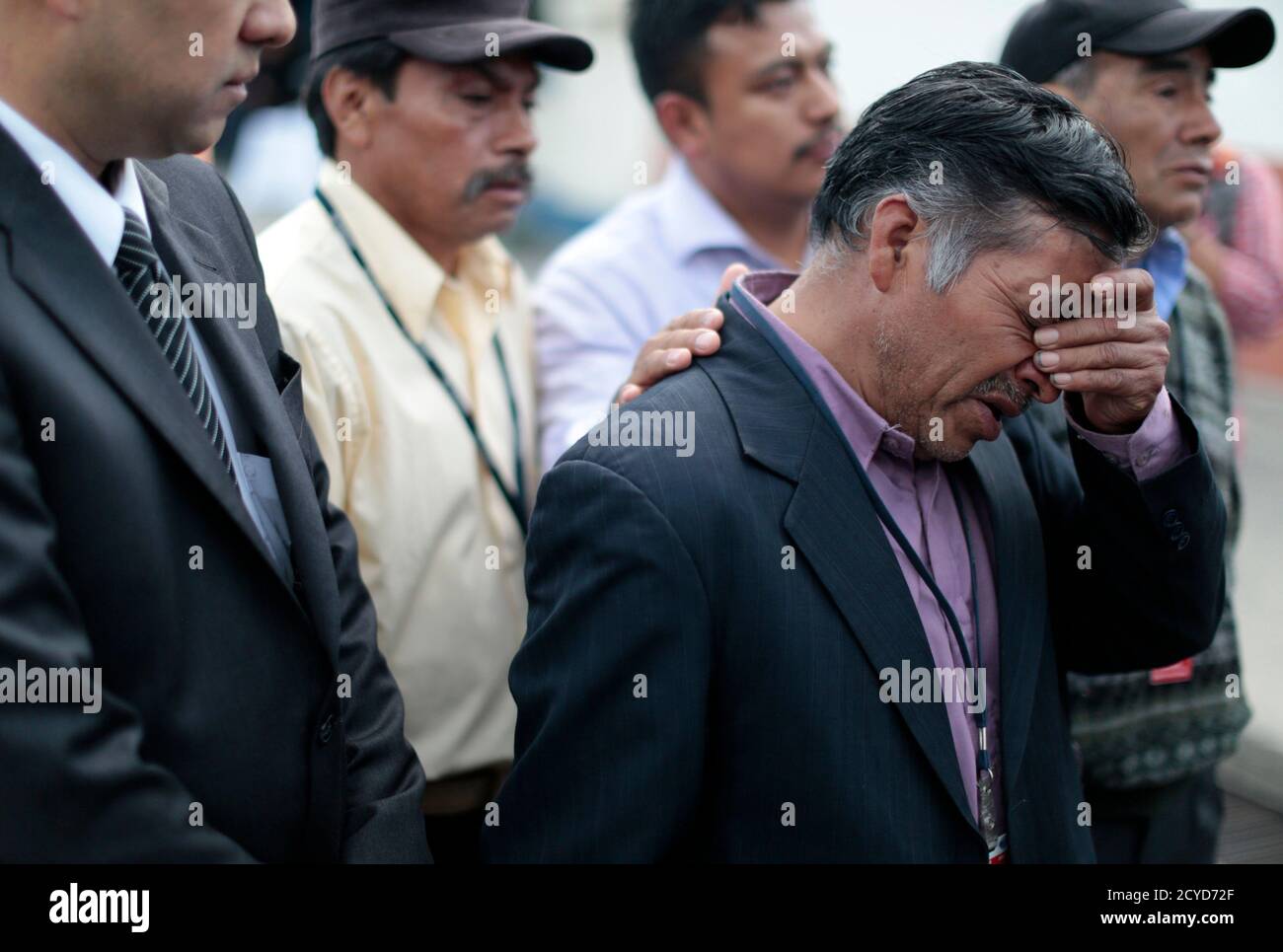 Pedro Salomon Garcia (R), uncle of Daysi Garcia, who was murdered by her  husband Miguel Mejia Ramos along with her children, reacts while awaiting  the repatriation of the bodies in Guatemala City,