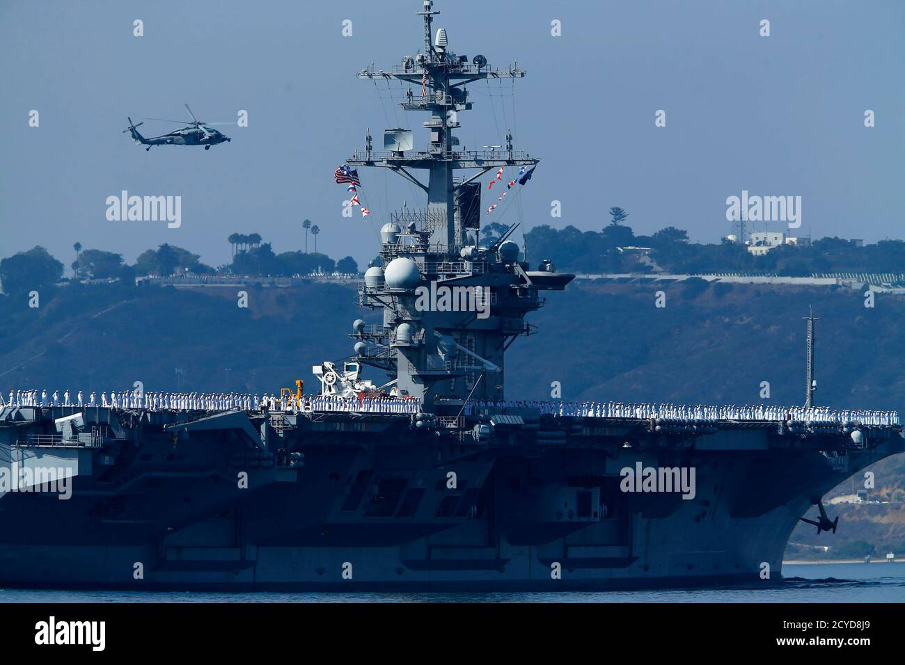 Sailors man the rails of the USS Carl Vinson, a Nimitz-class aircraft carrier, as it departs its home port in San Diego, California August 22, 2014. The aircraft carrier and its strike group, made up of guided-missile cruiser USS Bunker Hill, and guided-missile destroyers USS Gridley, USS Sterett and the USS Dewey, were deployed on Friday to the Western Pacific and Middle East.     REUTERS/Mike Blake (UNITED STATES - Tags: MILITARY POLITICS MARITIME CONFLICT) Stock Photo