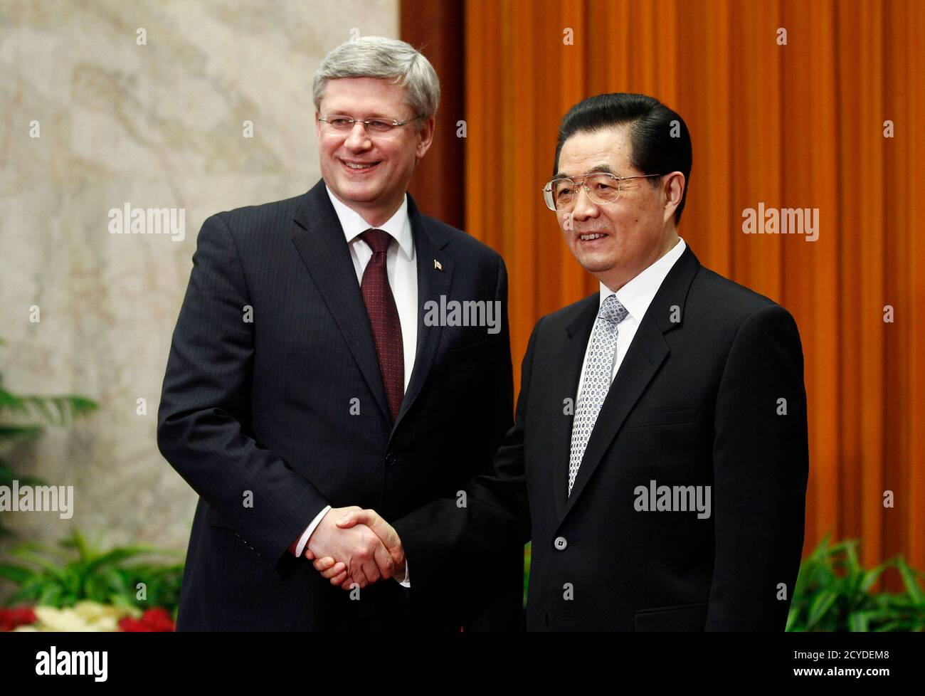 Canada's Prime Minister Stephen Harper (L) shakes hands with China's President Hu Jintao at the Great Hall of the People in Beijing February 9, 2012. China and Canada on Wednesday signed a series of deals to boost modest levels of bilateral trade and finished negotiations on a foreign investment protection pact after 18 years of talks.      REUTERS/Chris Wattie       (CHINA - Tags: POLITICS) Stock Photo