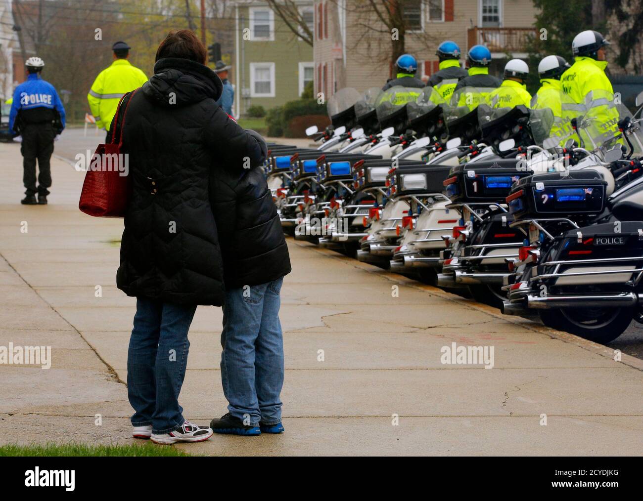 Heather Tighe and her 10 year-old son Brendan watch as police officers file  into St. Patrick's Church for the funeral for Massachusetts Institute of  Technology (MIT) police officer Sean Collier in Stoneham,