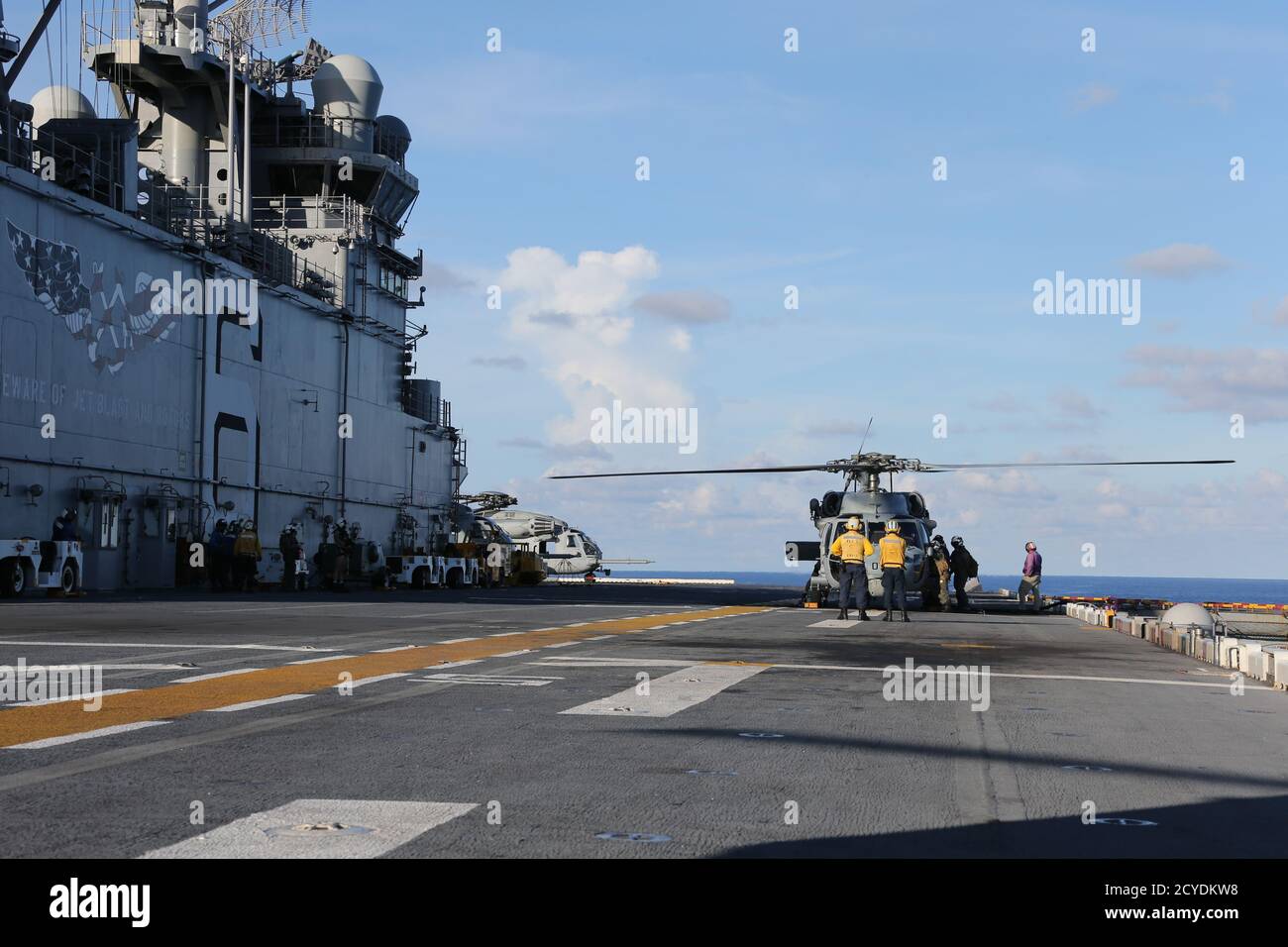 PHILIPPINE SEA (Sept. 27, 2020) U.S. Navy Sailors assigned to amphibious assault ship USS America (LHA 6) and Archangels of Helicopter Sea Combat Squadron (HSC) 25 Detachment 6 prepare an MH-60S Sea Hawk helicopter for takeoff from America’s flight deck. America, flagship of Expeditionary Strike Group Seven (ESG 7), along with the 31st Marine Expeditionary Unit, is operating in the U.S. 7th Fleet area of operations to enhance interoperability with allies and partners and serve as a ready response force to defend peace and stability in the Indo-Pacific region. (U.S. Marine Corps photo by 1st Lt Stock Photo