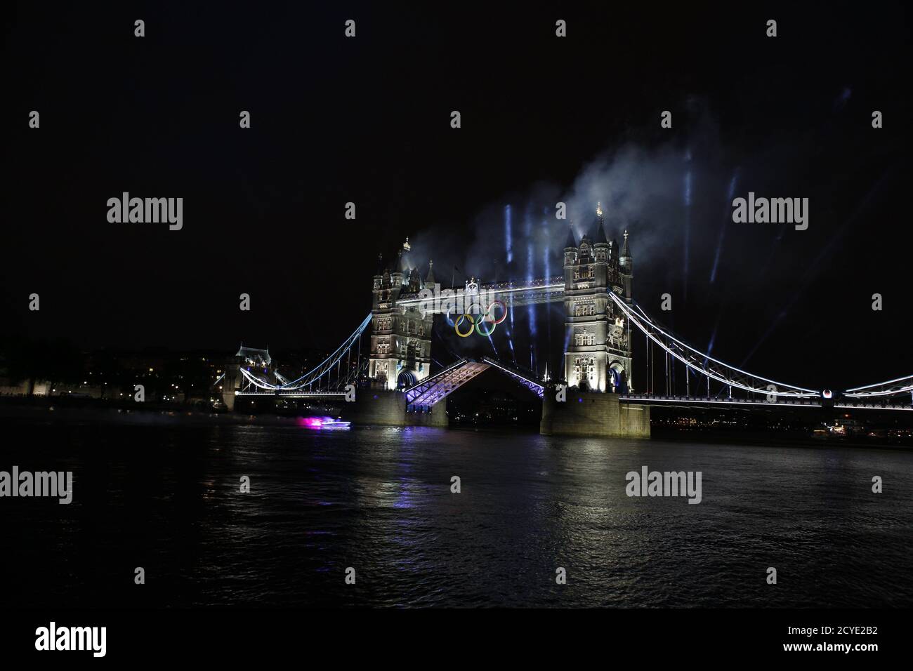 A speedboat carrying footballer David Beckham holding the Olympic torch, races under the Tower Bridge during the opening ceremony of London 2012 Olympic Games July 27, 2012. REUTERS/Mark Blinch (BRITAIN - Tags: SPORT OLYMPICS) BEST QUALITY AVAILABLE Stock Photo