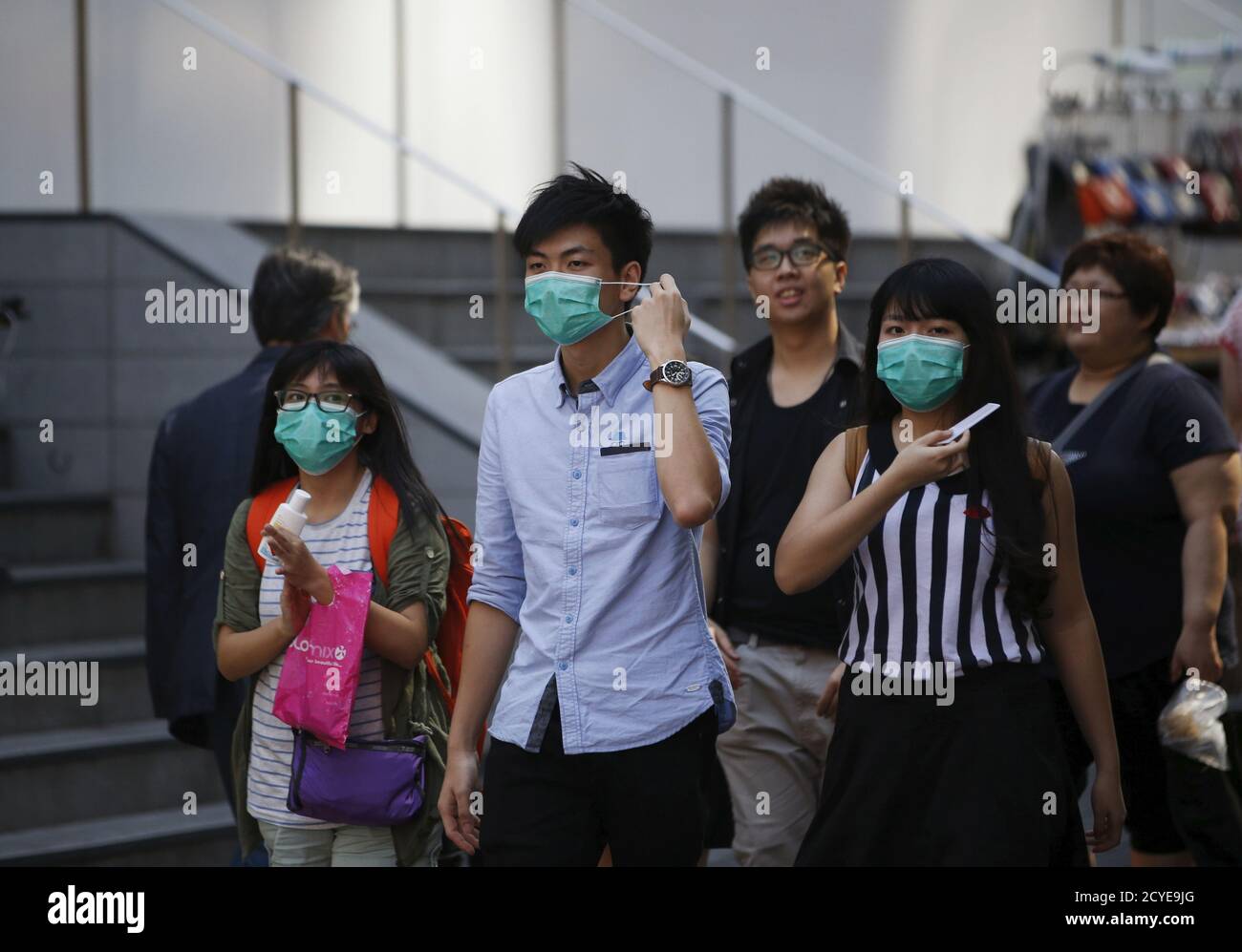 Tourists wearing masks to prevent contracting Middle East Respiratory Syndrome (MERS), walk at Myeongdong shopping district in central Seoul, South Korea June 3, 2015. South Korea confirmed five more cases of the Middle East Respiratory Syndrome (MERS) virus, the health ministry said early on Wednesday, bringing to 30 the total number of cases in the country of the often-deadly illness.  REUTERS/Kim Hong-Ji Stock Photo