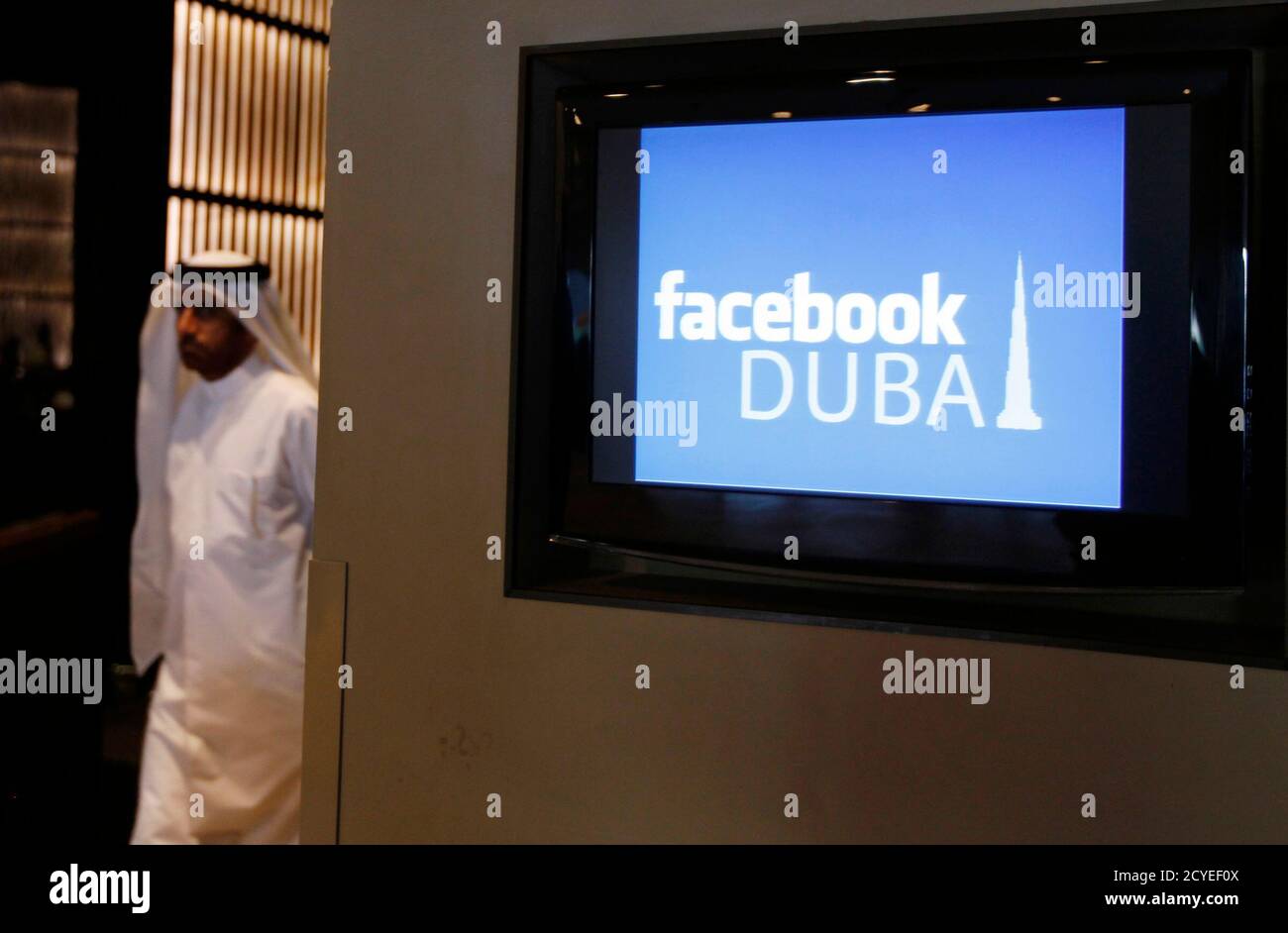 A Man Walks Past A Screen During A News Conference Announcing The Opening Of Facebook Offices In Dubai May 30 2012 Social Networking Site Facebook Opens Its First Office In The Middle