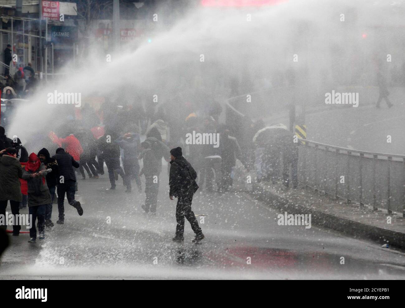 Protesters run from water cannons used by riot police to disperse them during a protest march to commemorate the death of Berkin Elvan, in Istanbul March 11, 2015. Riot police fired water cannons to disperse protesters in Istanbul as they marched to mark the anniversary of the death of Elvan, the 15-year-old boy who suffered a head injury during anti-government protests in Istanbul in 2012, dying on March 11, 2013 after spending months in a coma.   REUTERS/Osman Orsal (TURKEY - Tags: POLITICS CIVIL UNREST CRIME LAW) Stock Photo