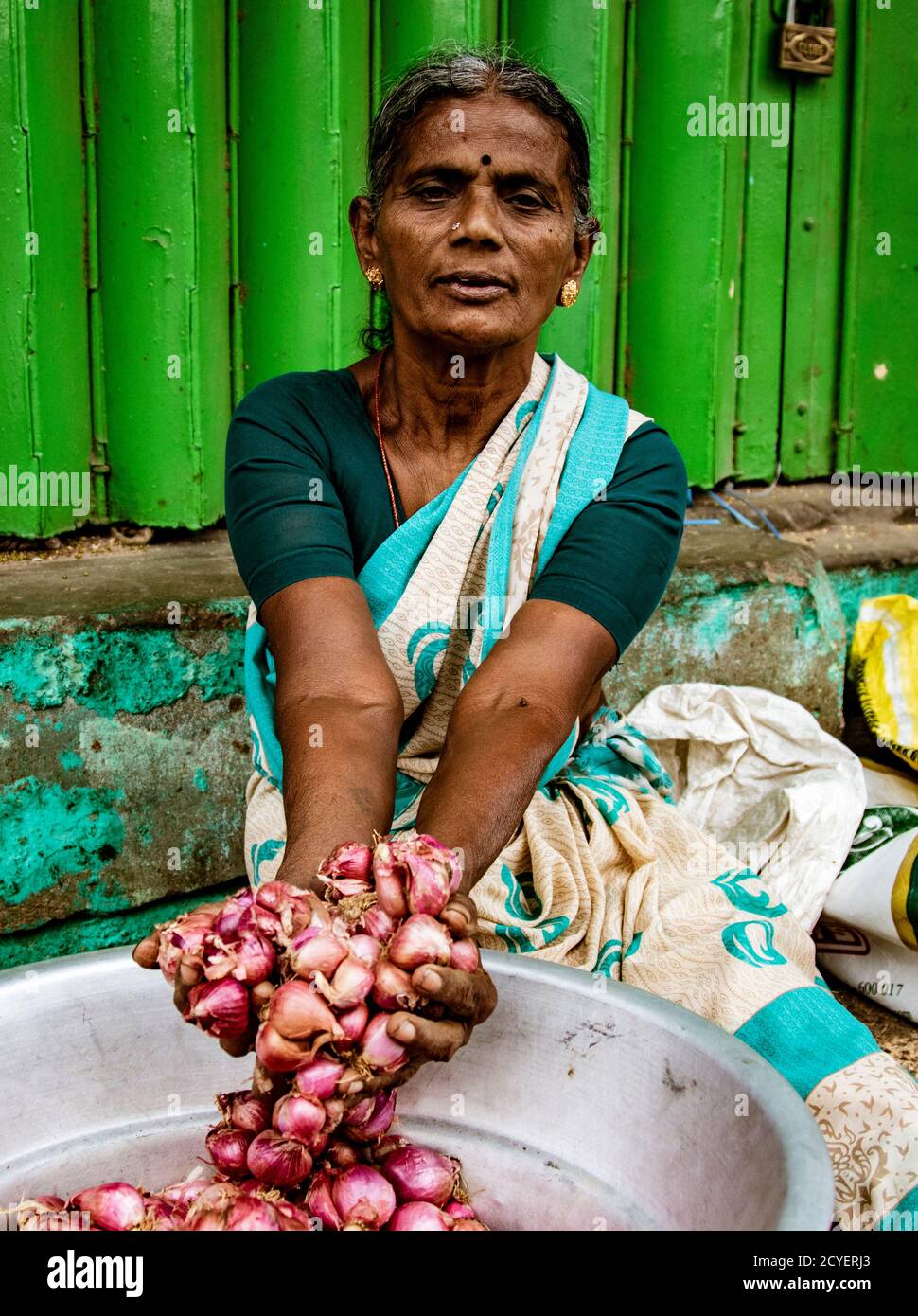 Madurai, India, Mar 8, 2018 - Woman shows the onions she is selling Stock Photo