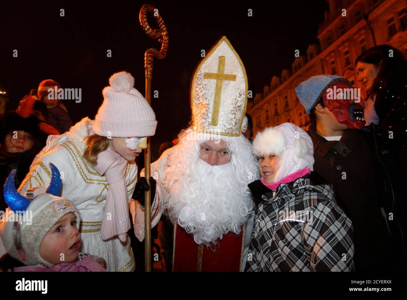 Revellers Dressed As An Angel And Saint Nicholas Listen To Children As They Report On Their