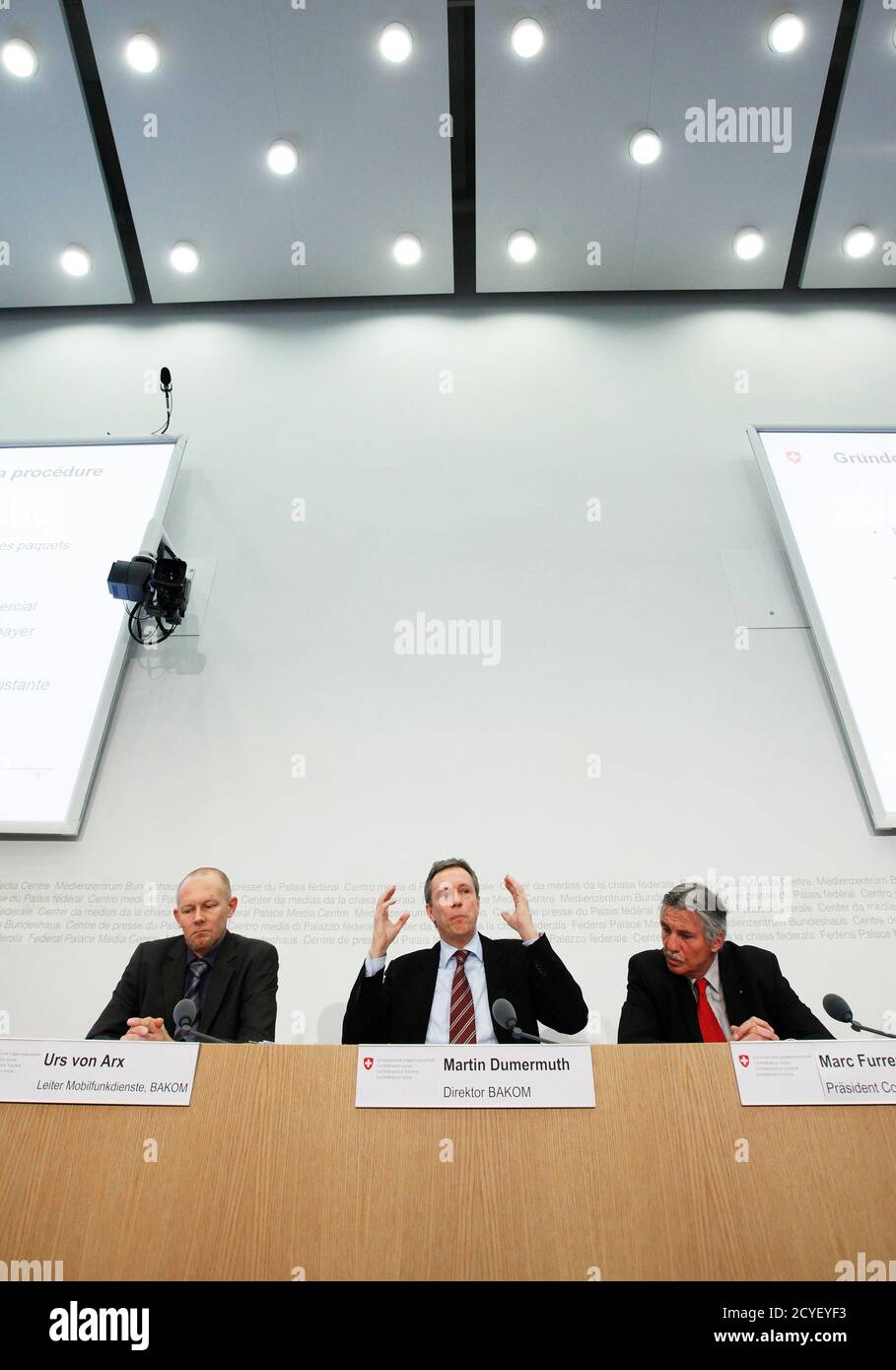 Director general of the Federal Office of Communications (BAKOM) Martin  Dumermuth (C) gestures next to the President of Swiss Federal Communication  Comission (COMCOM) Marc Furrer (R) and Urs Von Arx, Head of