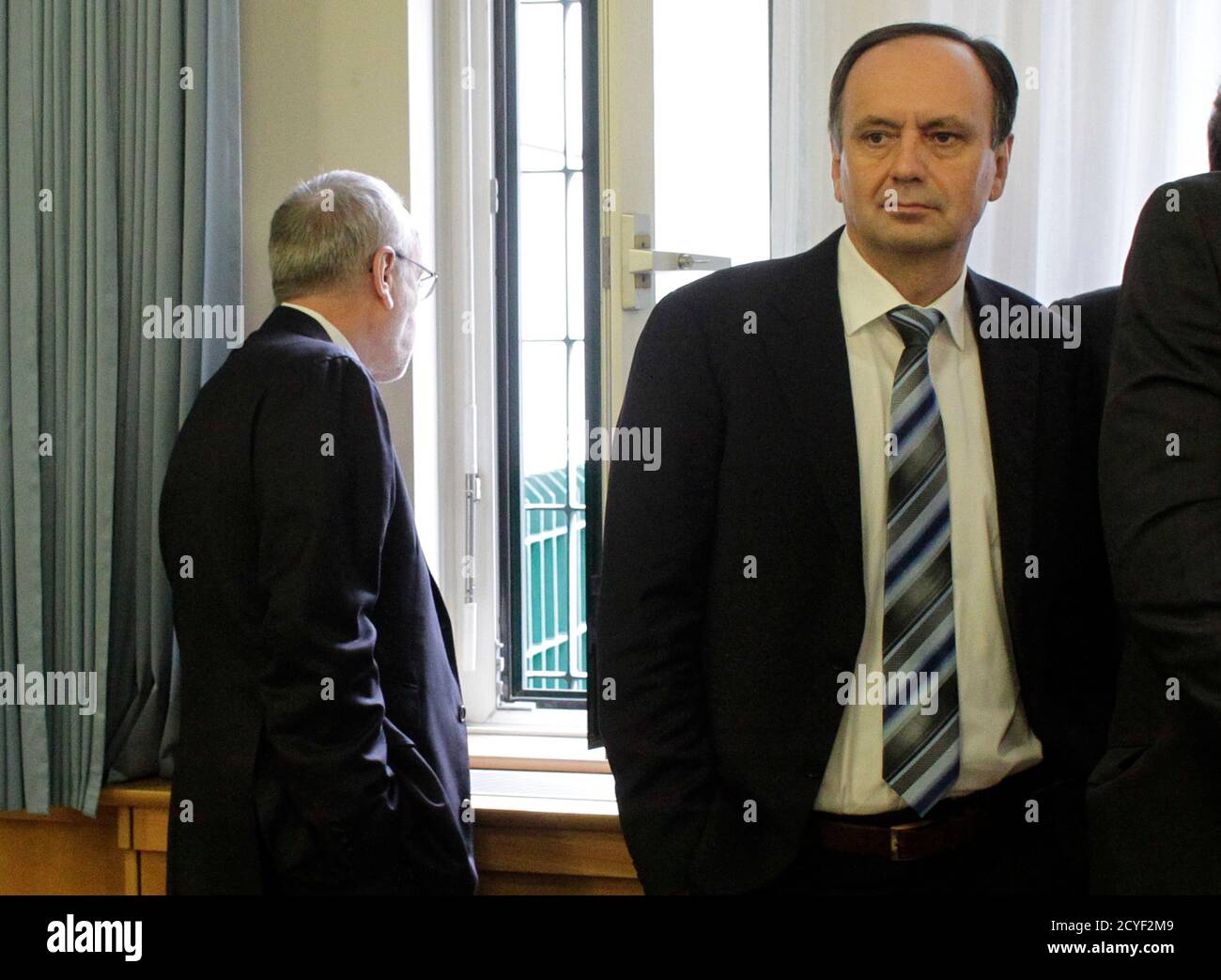 Former Telekom Austria manager Rudolf Fischer (L) and ex-wholesale manager Josef Trimmel wait for their share manipulation trial at a court in Vienna February 27, 2013. Three former Telekom Austria top managers, along with another former employee and a banker are charged with arranging the mass buying of Telekom Austria shares in 2004, causing a surge in the price that triggered a payout of 9 million euro ($12 million) for managers. REUTERS/Herwig Prammer  (AUSTRIA - Tags: BUSINESS CRIME LAW TELECOMS) Stock Photo
