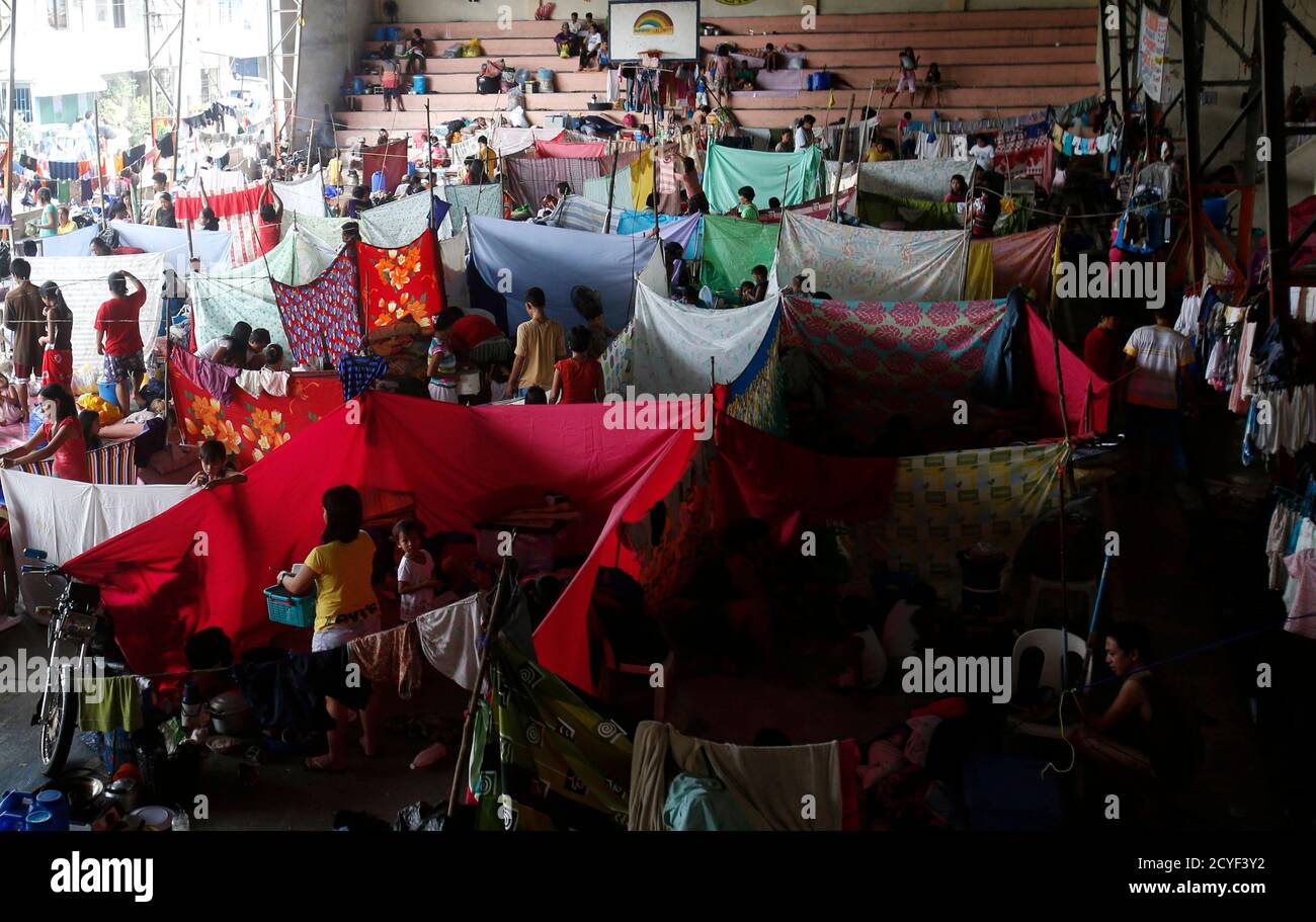 Flood victims stay at an evacuation centre after their homes were swamped with floodwaters in Calumpit, Bulacan, north of Manila, August 22, 2013. The southwest monsoon that wreaked havoc on Metro Manila and nearby areas earlier this week is likely to weaken now that Typhoon Trami made landfall over China, state weather forecasters said Thursday. The death toll from the heavy monsoon rain and floods since last weekend rose to at least 16 as of Thursday morning, the National Disaster Risk Reduction and Management Council said. REUTERS/Erik De Castro (PHILIPPINES - Tags: DISASTER ENVIRONMENT) Stock Photo