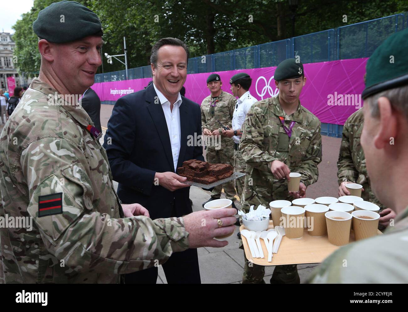 Britain's Prime Minister David Cameron hands out brownies as he meets with soldiers from 5th Battalion The Rifles on security duty near Downing Street in London August 2, 2012. REUTERS/Peter Macdiarmid/pool     (BRITAIN - Tags: MILITARY POLITICS SPORT OLYMPICS) Stock Photo
