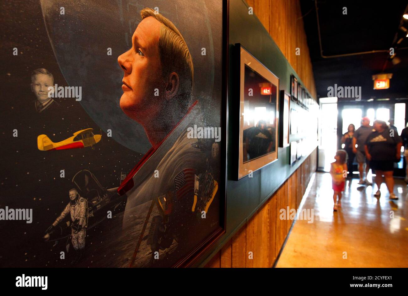 Visitors walk by a portrait of Neil Armstrong before a public memorial service for Armstrong at the Armstrong Air and Space Museum in Wapakoneta, Ohio August 29, 2012. Armstrong, who took a giant leap for mankind when he became the first person to walk on the moon, has died at the age of 82, his family said on Saturday.  REUTERS/Matt Sullivan  (UNITED STATES - Tags: SCIENCE TECHNOLOGY OBITUARY PROFILE) Stock Photo