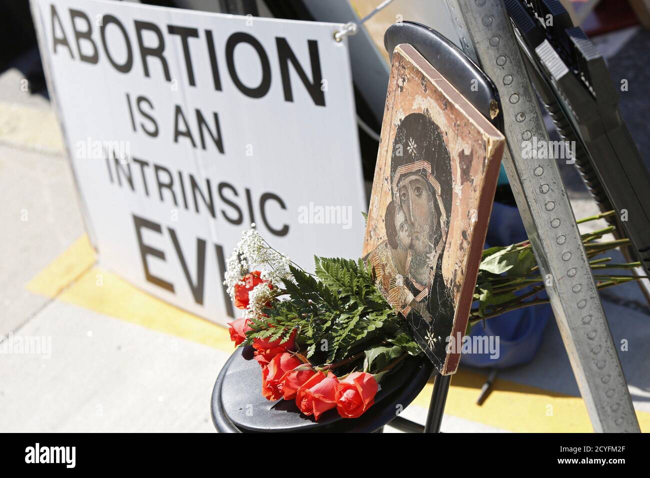 A sign with flowers and a portrait of Jesus is seen in front of a Planned Parenthood clinic in Boston, Massachusetts, June 28, 2014. Massachusetts is beefing up security around abortion clinics and scrambling for a legal fix after the U.S. Supreme Court voided the state's buffer zone law that kept protesters 35 feet away, saying it violated freedom of speech. Boston, Worcester and Springfield, the state's largest cities, have deployed extra police to clinics, and abortion-provider Planned Parenthood said it was training new 'patient escorts' to help women through protests if needed. REUTERS/Do Stock Photo