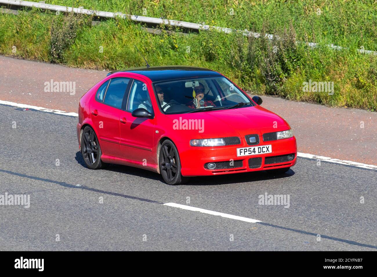2004 red SEAT Leon FR TDI; Vehicular traffic, moving vehicles, cars, vehicle driving on UK roads, motors, motoring on the M6 motorway highway road network. Stock Photo