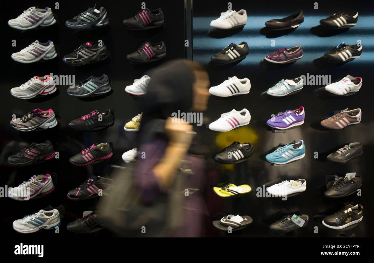 An Iranian woman walks past a window of an Adidas store in northern Tehran  October 24, 2010. While ordinary Iranians struggle to survive international  sanctions and deepening economic uncertainty, the gap has