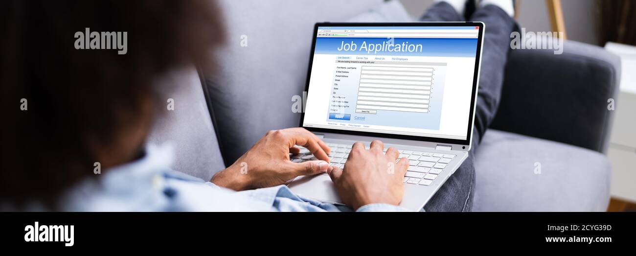 African American Man Sending Corporate Resume On Laptop Stock Photo