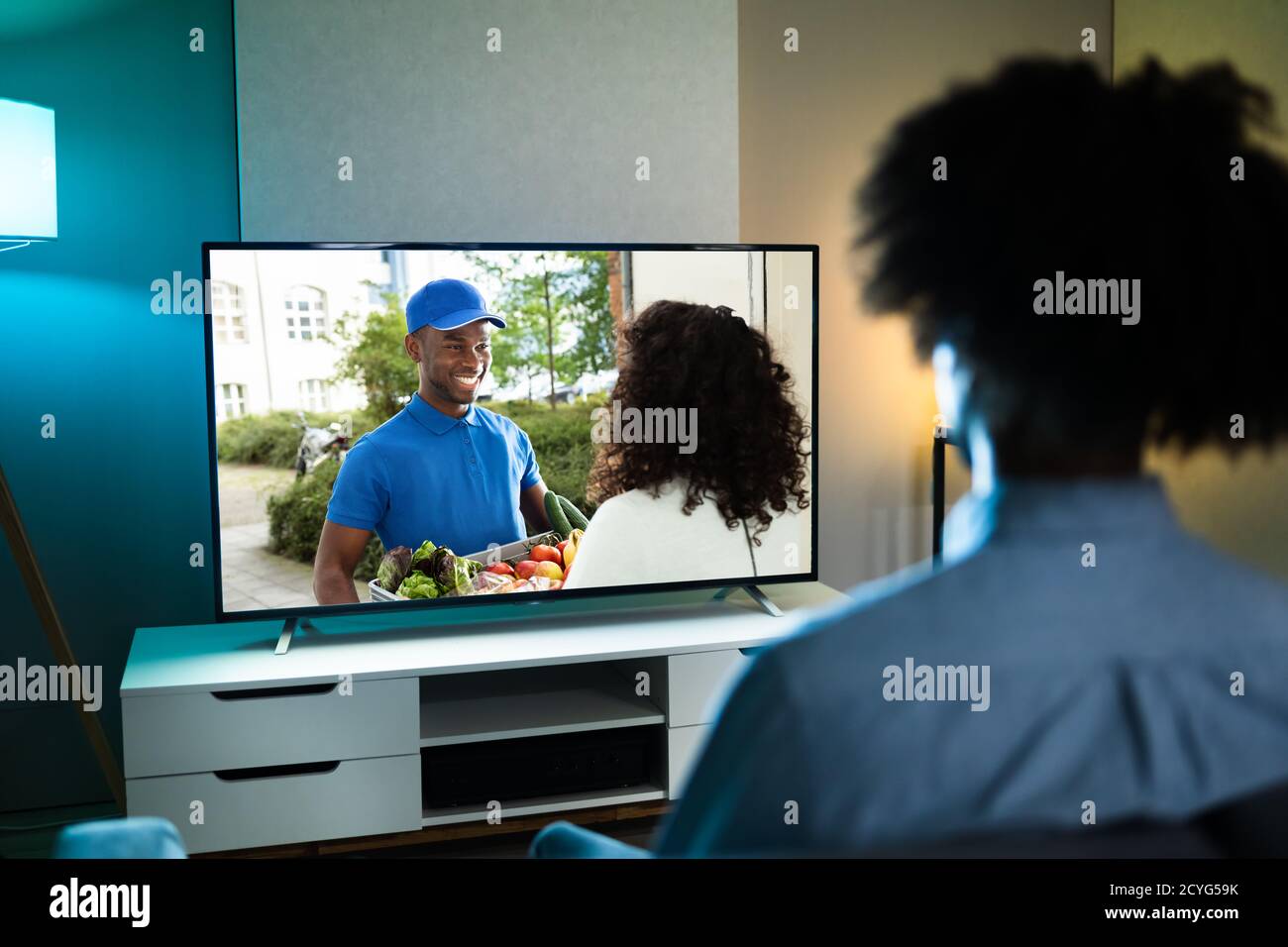 African Man Watching TV Movie Or Television Stock Photo