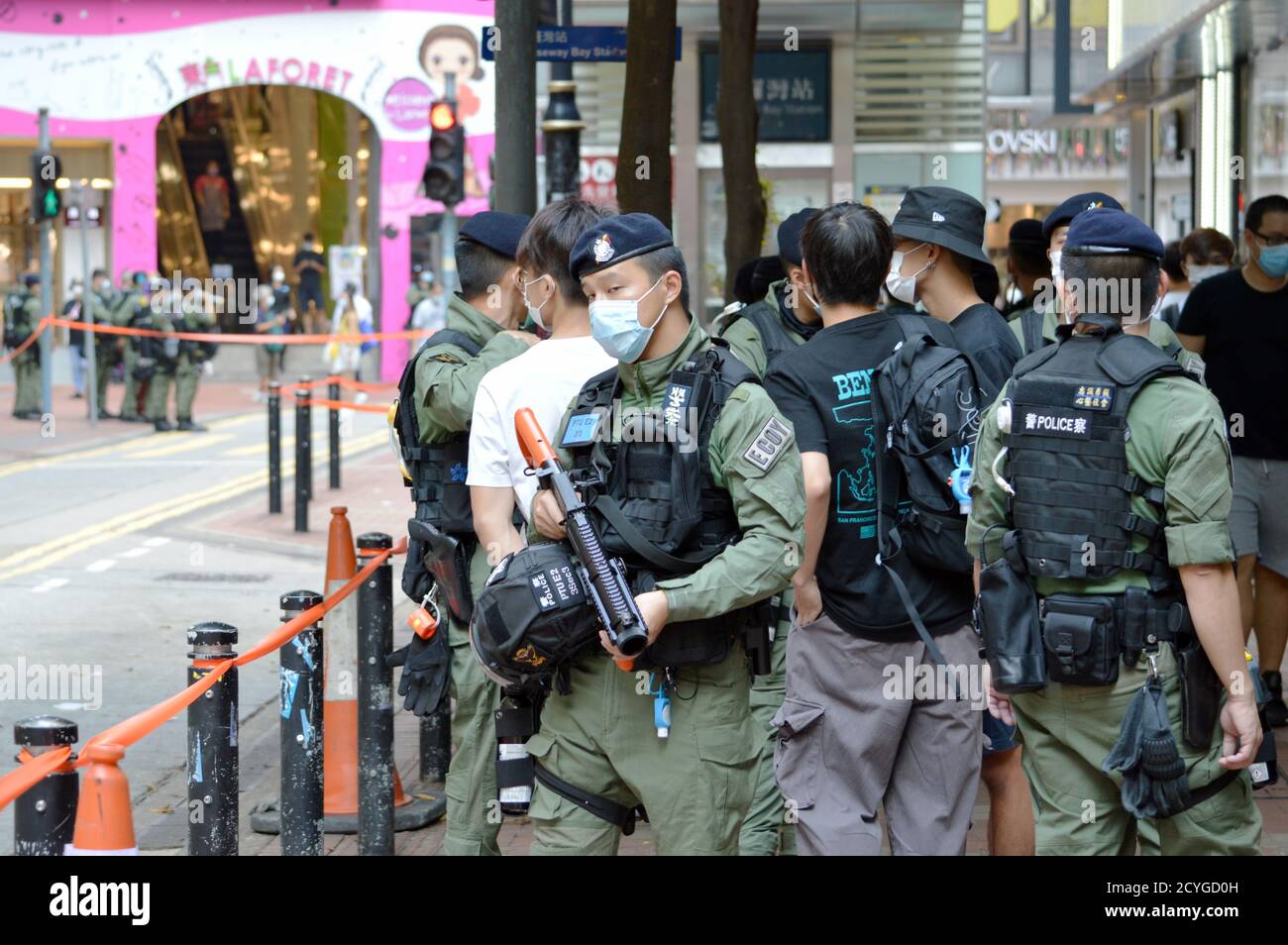 Hong Kong Police Force officer standing with weapon in Causeway Bay shopping district on National Day, 1 October 2020 Stock Photo